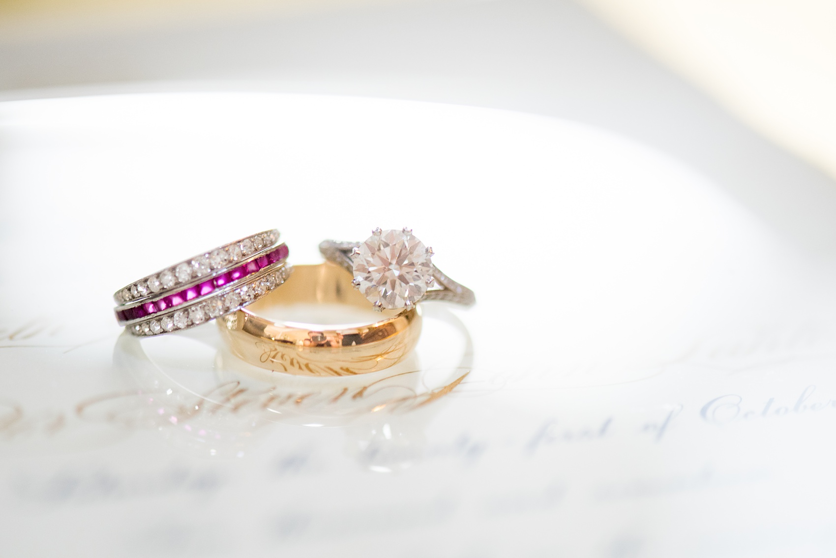 Mikkel Paige Photography photo of a wedding in Chapel Hill at Duke Chapel. Bride and groom with the gothic architecture. A detail photo of the couple's diamond and ruby rings and wedding invitation.