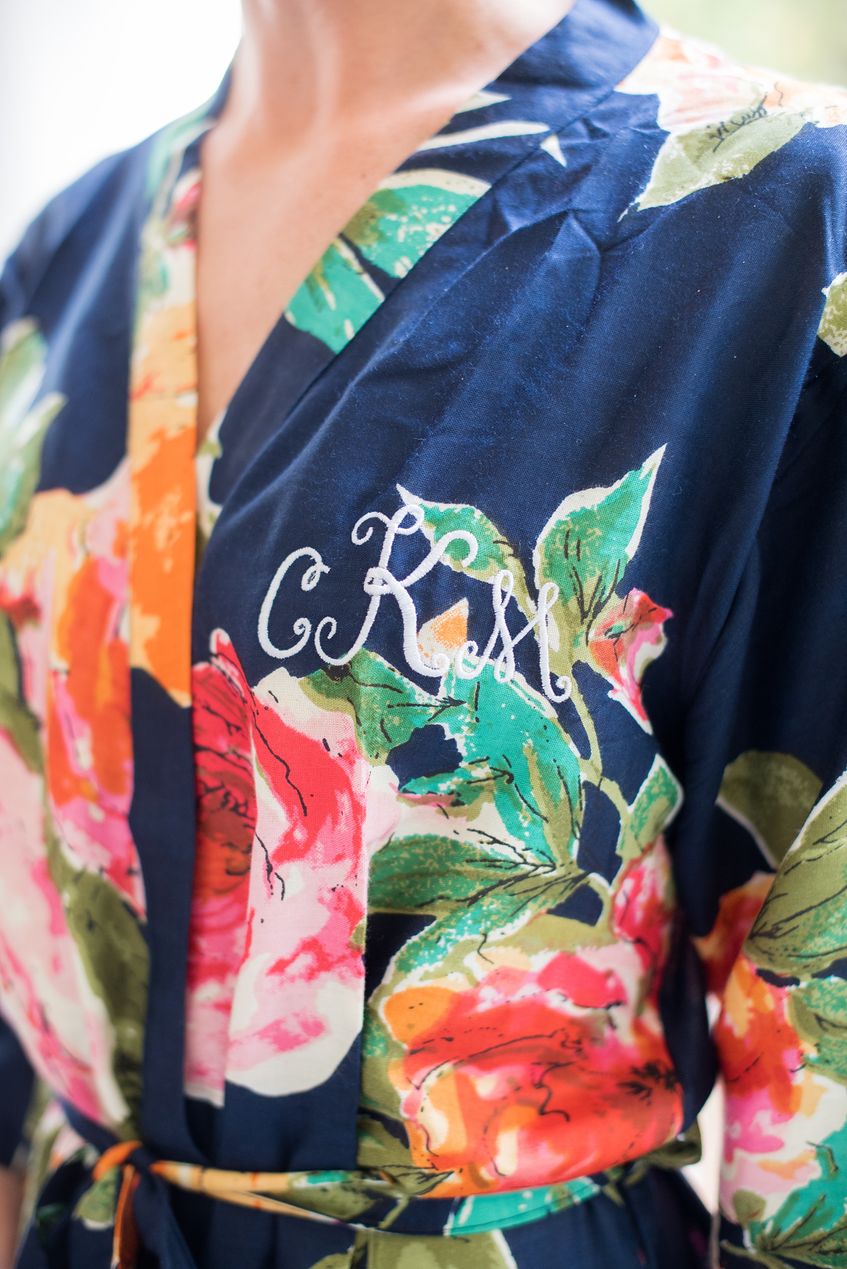 Mikkel Paige Photography photo of a wedding in Chapel Hill at Duke Chapel. Detail picture of the embroidered letters on the bridesmaids blue floral robes. 