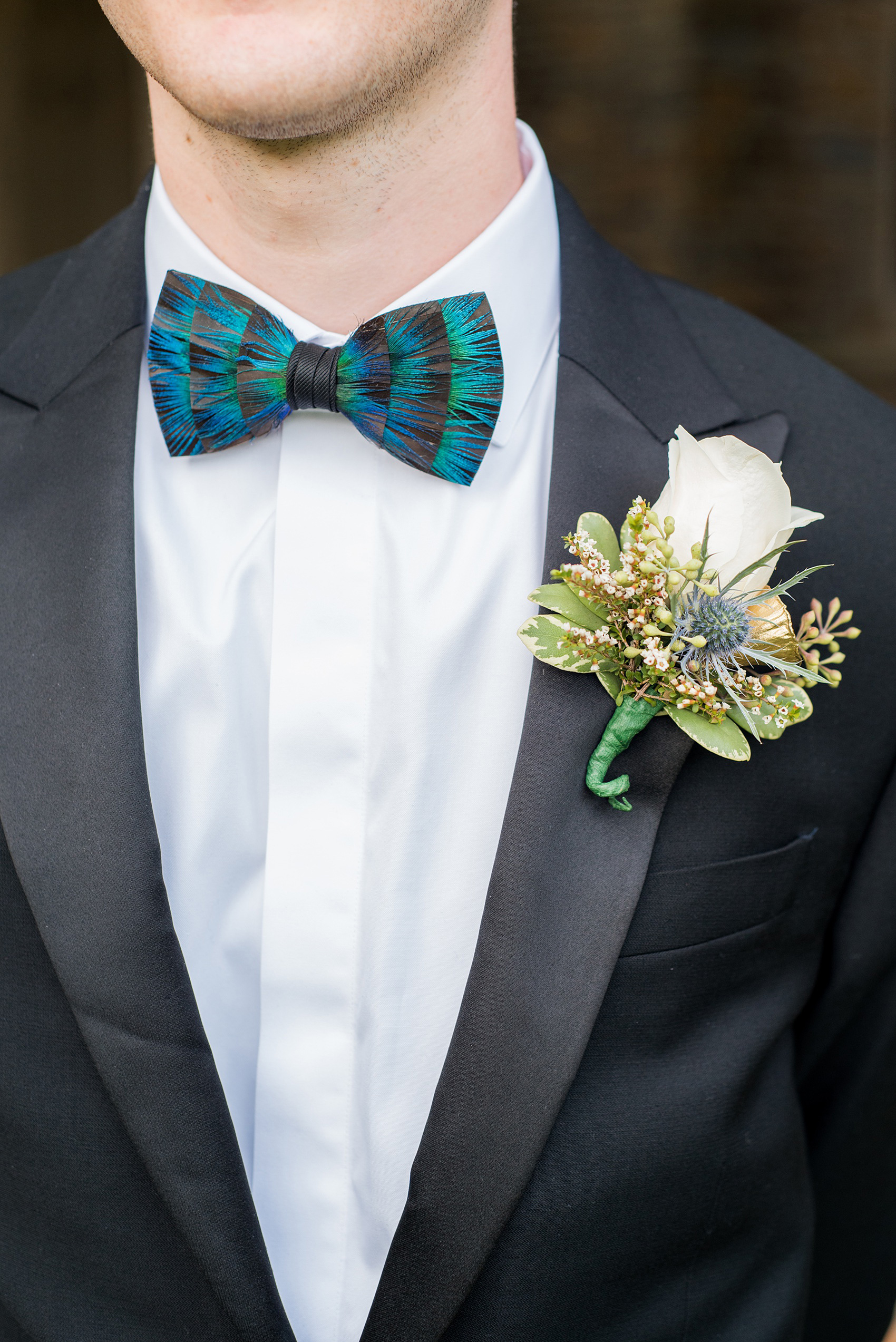 Mikkel Paige Photography photo of a wedding in Chapel Hill at Duke Chapel. A picture of the grooms feather bow tie and rose fall boutonniere. 