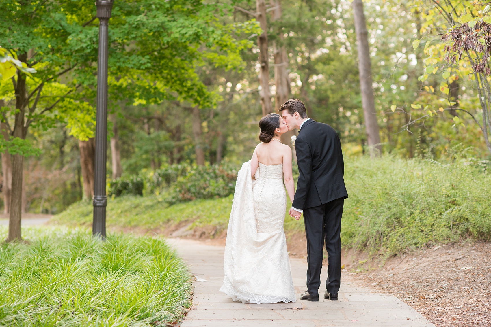 Mikkel Paige Photography photo of a wedding in Chapel Hill at Duke Chapel. A picture of the bride and groom walking and kissing on the church property.