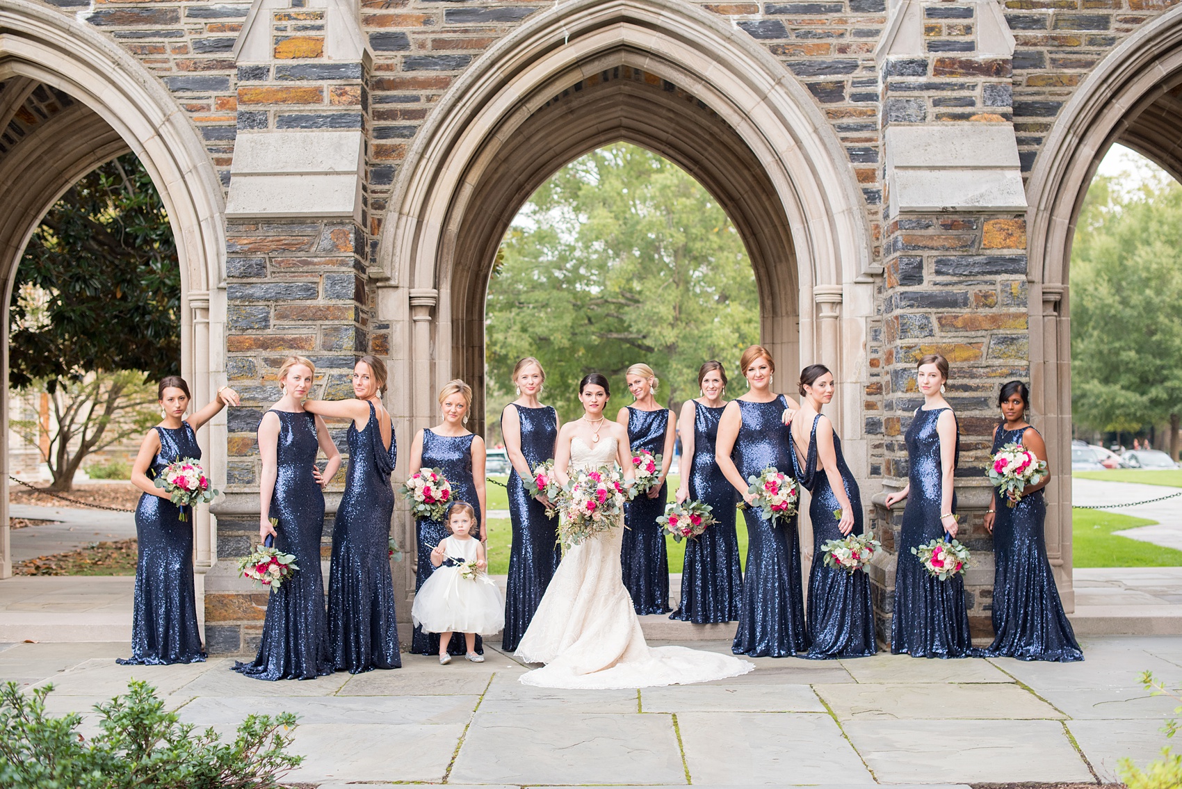 Mikkel Paige Photography photo of a wedding in Chapel Hill at Duke Chapel. Vogue like picture of the bridal party in blue sequin, low back gowns with the gothic architecture of the church.