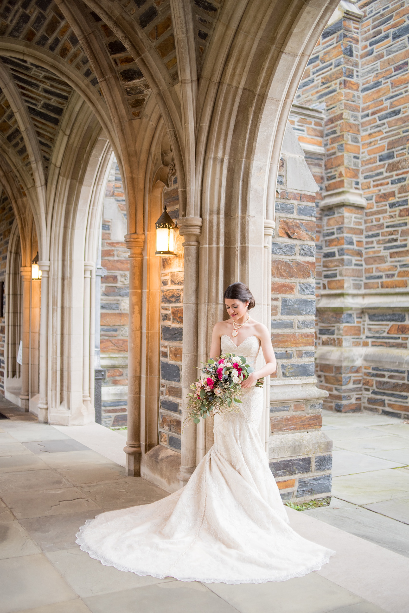 Mikkel Paige Photography photo of a wedding in Chapel Hill at Duke Chapel. Bride and groom with the gothic architecture. A portrait picture of the bride in the gothic arches of the church.