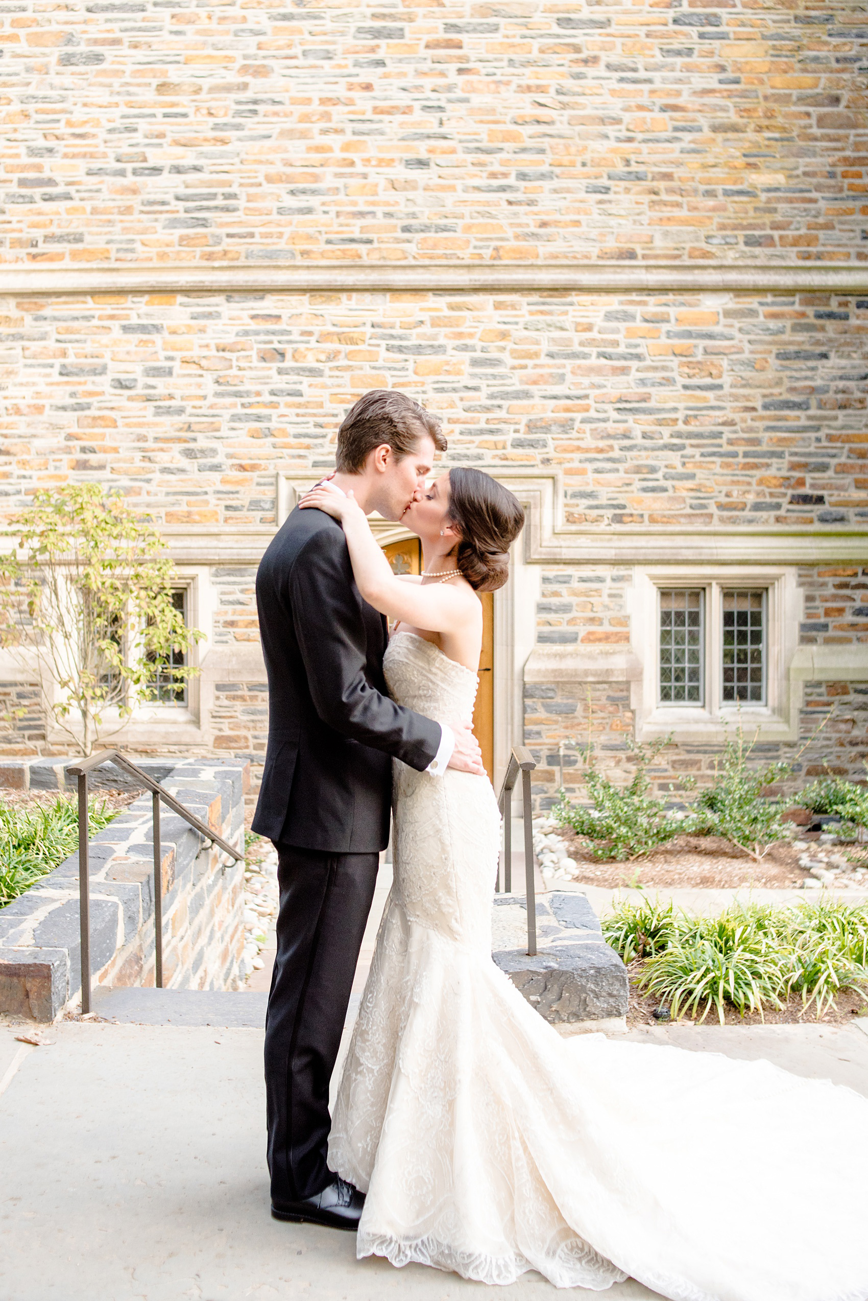 Mikkel Paige Photography photo of a wedding in Chapel Hill at Duke Chapel. Bride and groom with the gothic architecture. A picture of the couple kissing in front of the stone of the gothic church.