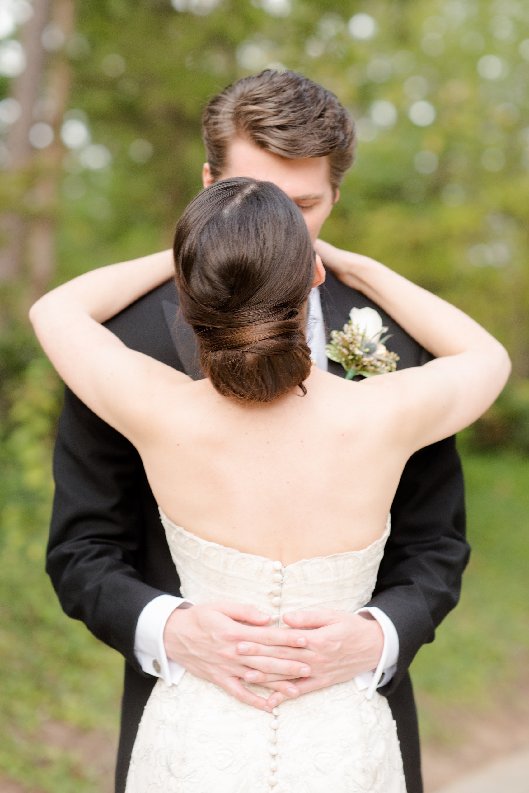 Mikkel Paige Photography photo of a wedding in Chapel Hill at Duke Chapel. Bride and groom with the gothic architecture. A picture of the couple kissing with the bride's creative low bun shown.