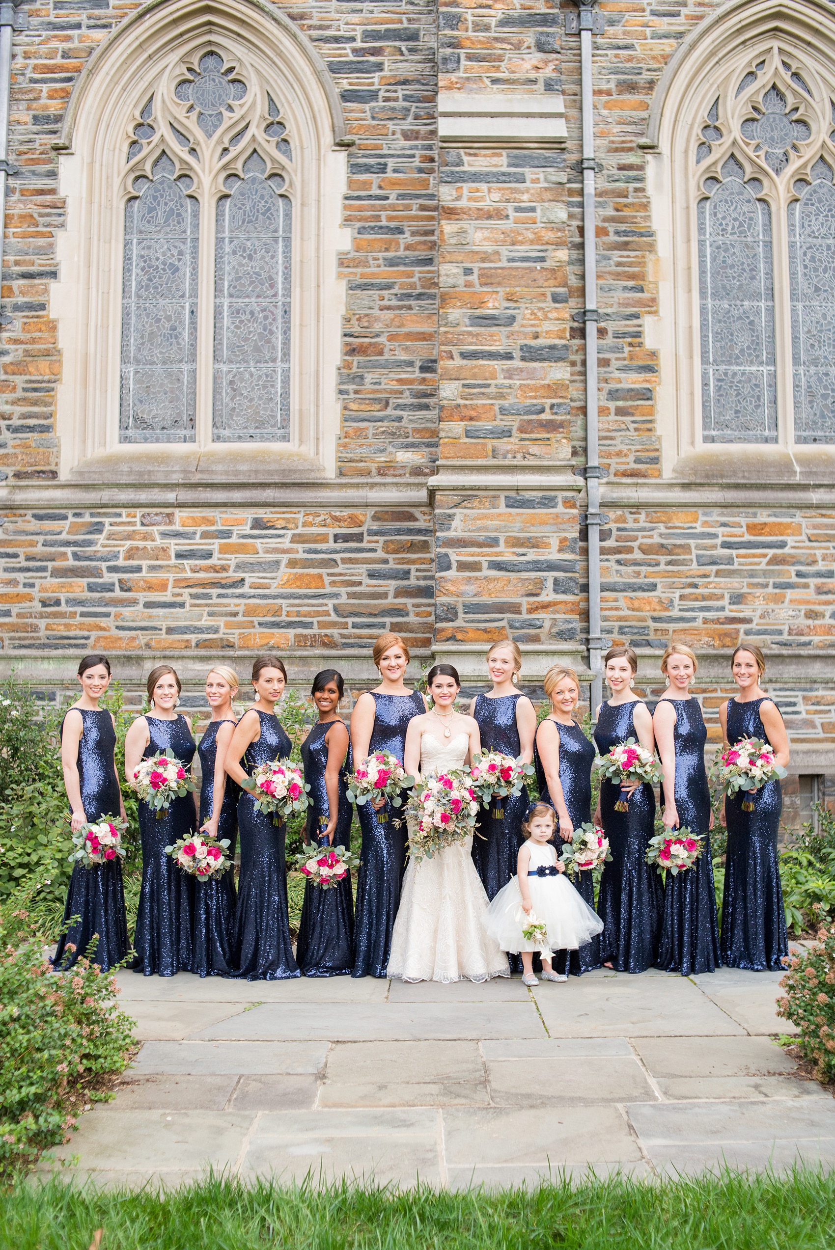 Mikkel Paige Photography photo of a wedding in Chapel Hill at Duke Chapel. Vogue like picture of the bridal party in blue sequin, low back gowns with the gothic architecture of the church.
