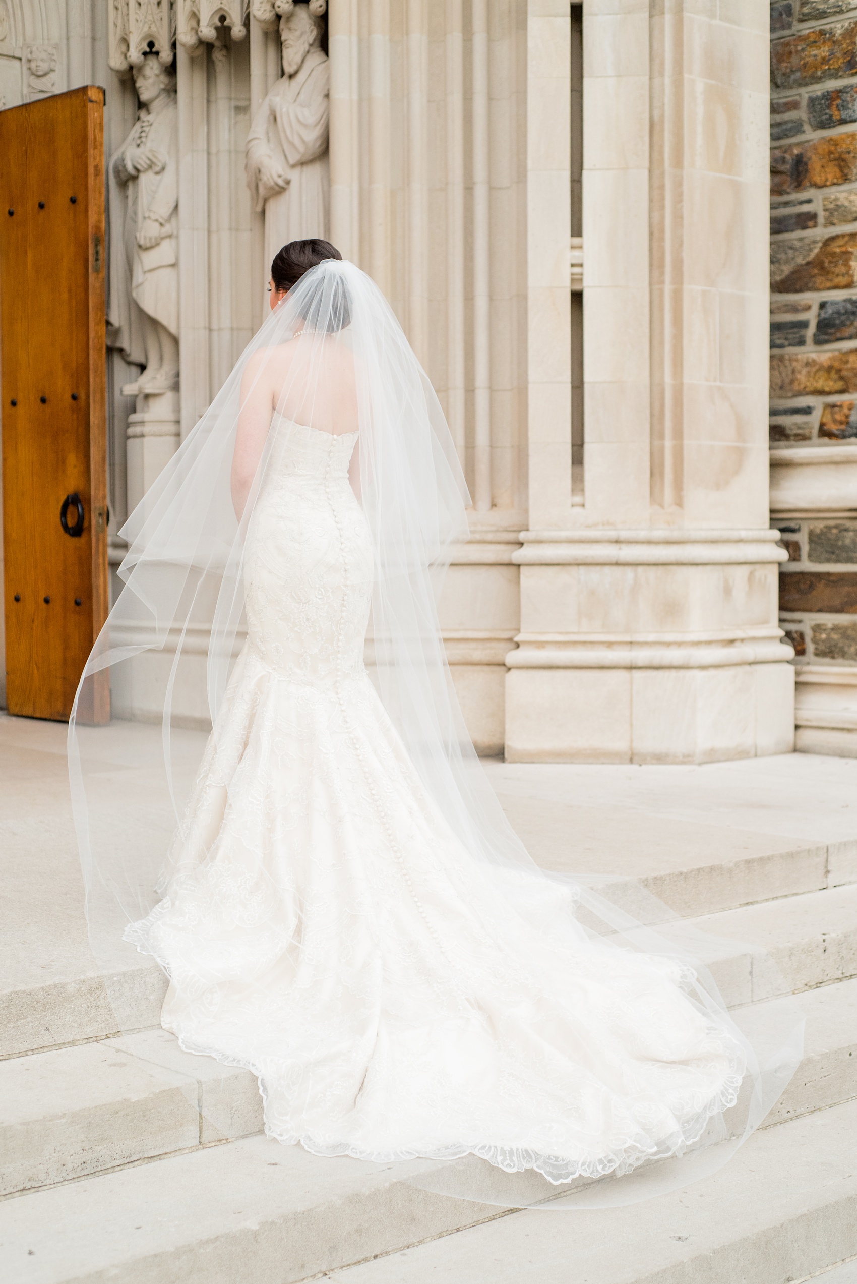 Mikkel Paige Photography photo of a wedding in Chapel Hill at Duke Chapel. Bride and groom with the gothic architecture. A portrait picture of the bride in front of the gothic church with her tulle veil.