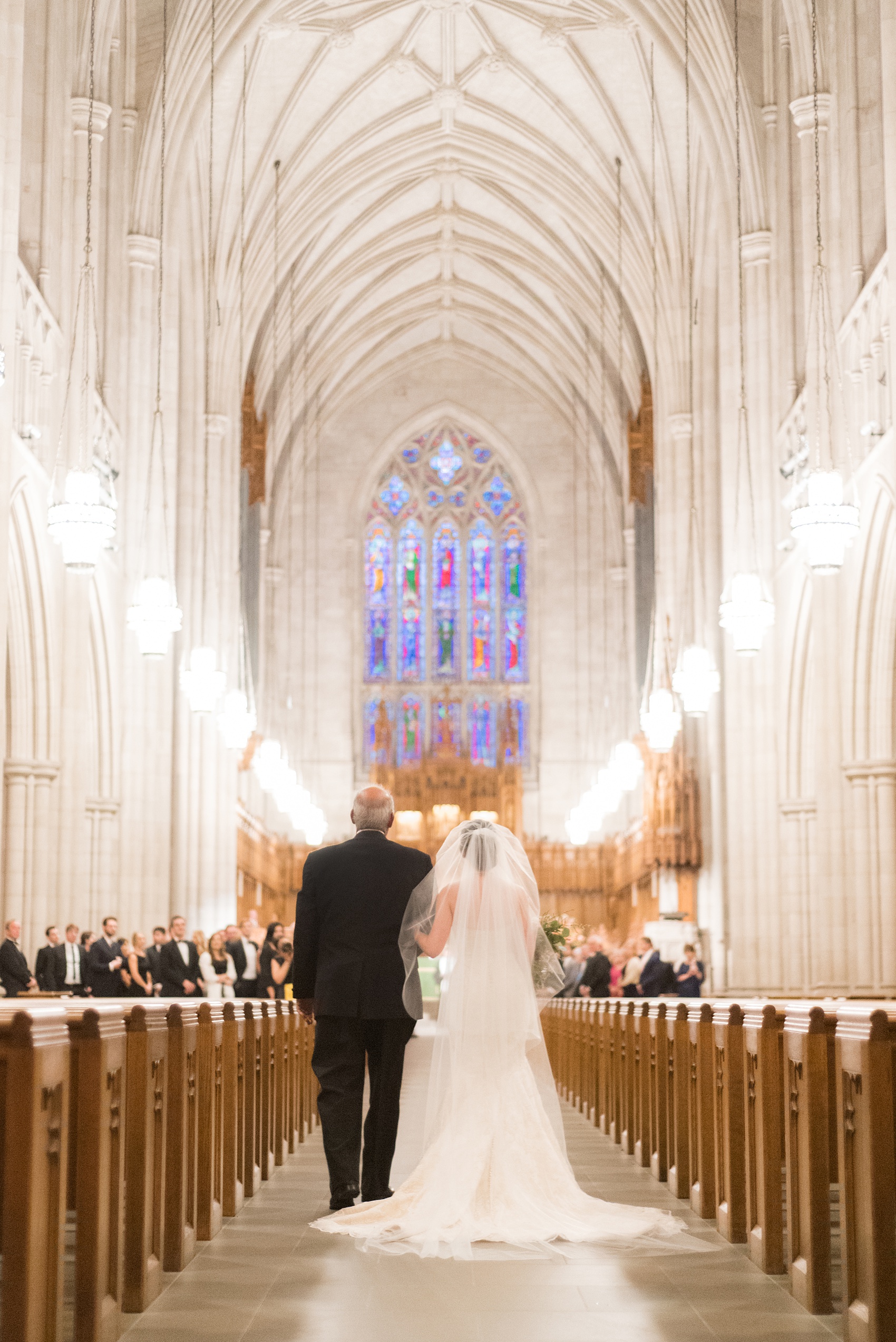 Mikkel Paige Photography photo of a wedding in Chapel Hill at Duke Chapel. Bride and groom with the gothic architecture. Picture of the bride and her father walking down the aisle inside the gothic church.