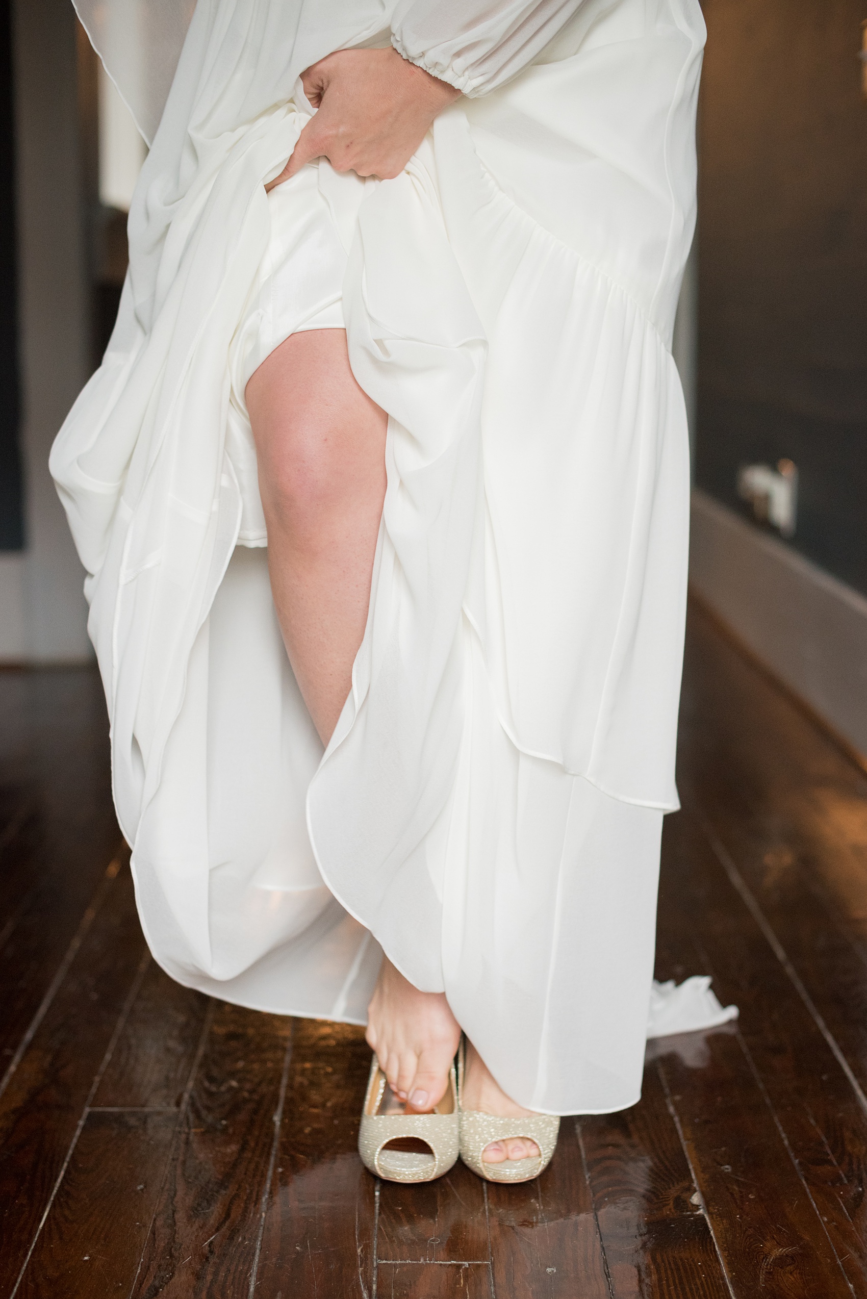 Mikkel Paige Photography photos from a wedding at Leslie-Alford Mims House in North Carolina. Picture of the bride stepping into her metallic gold shoes.