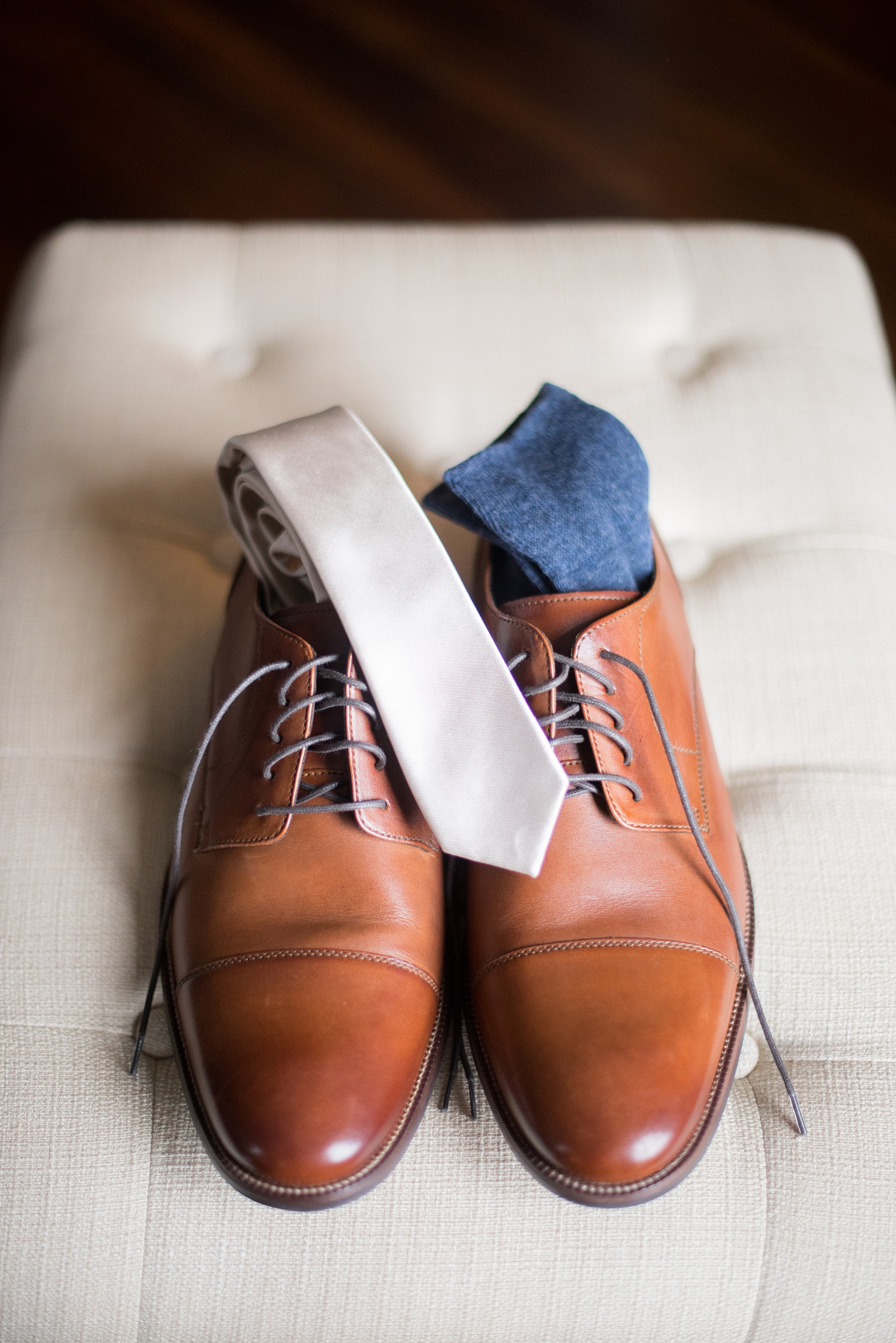 Mikkel Paige Photography photos from a wedding at Leslie-Alford Mims House in North Carolina. Picture of the groom's brown leather shoes, navy socks and off white tie.