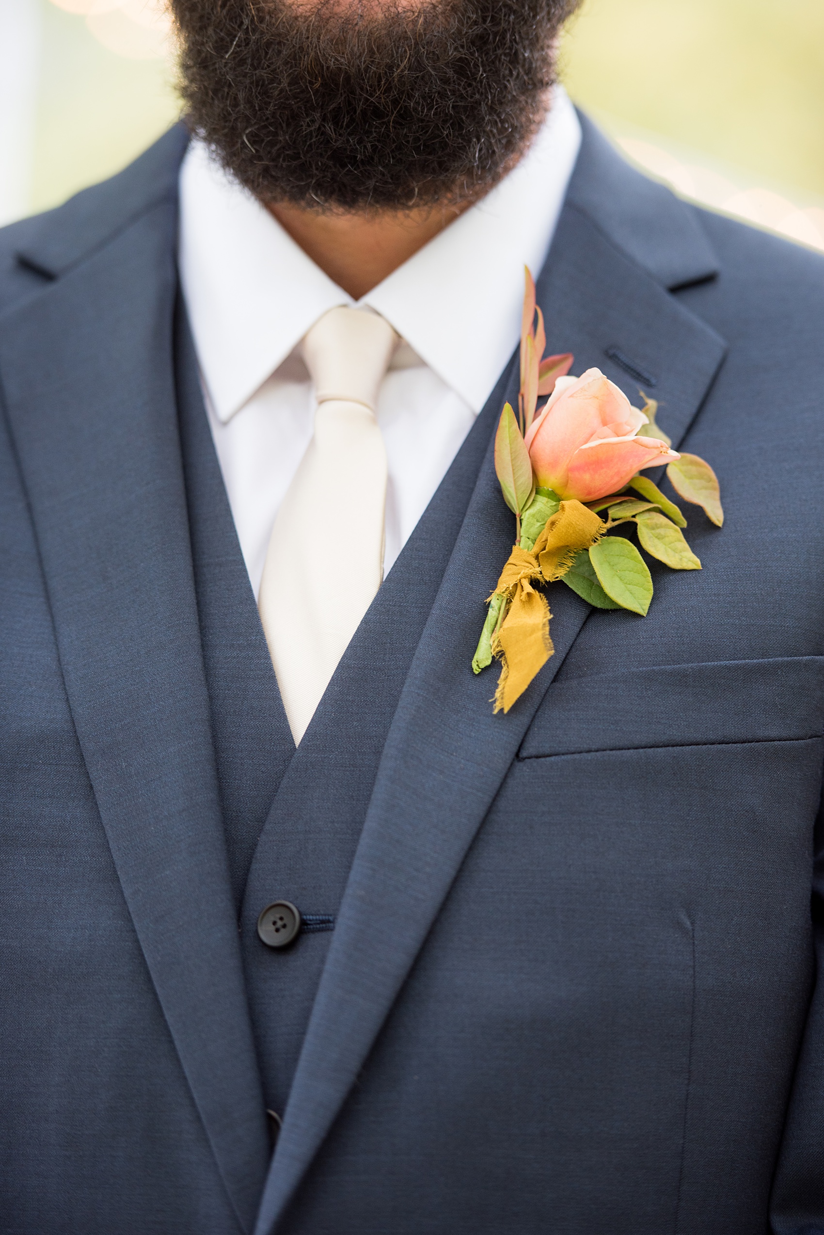 Mikkel Paige Photography photos from a wedding at Leslie-Alford Mims House in North Carolina. Detail picture of the groom's double breasted navy linen suit and fall boutonniere.