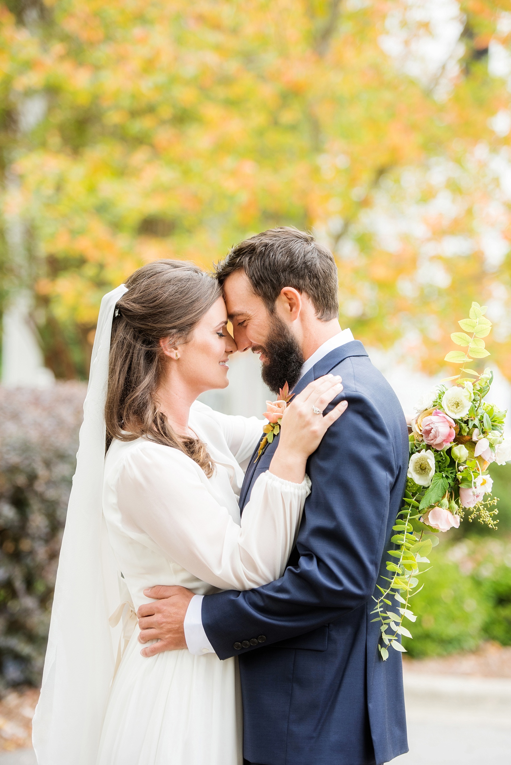 Mikkel Paige Photography photos from a wedding at Leslie-Alford Mims House in North Carolina. Picture of the Boho bride and groom in a navy suit for their Mad Dash Wedding, complete with colorful fall foliage.