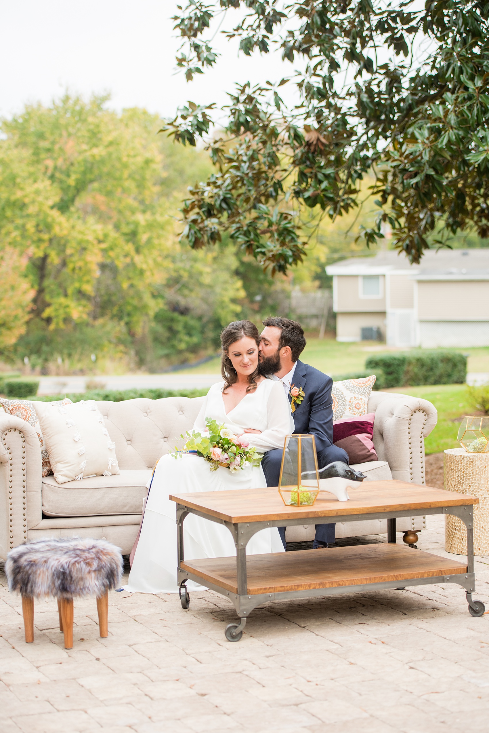 Mikkel Paige Photography photos from a wedding at Leslie-Alford Mims House in North Carolina. Photo of the bride and groom on their outdoor reception lounge furniture from Greenhouse Picker Sisters for a Mad Dash Weddings event.