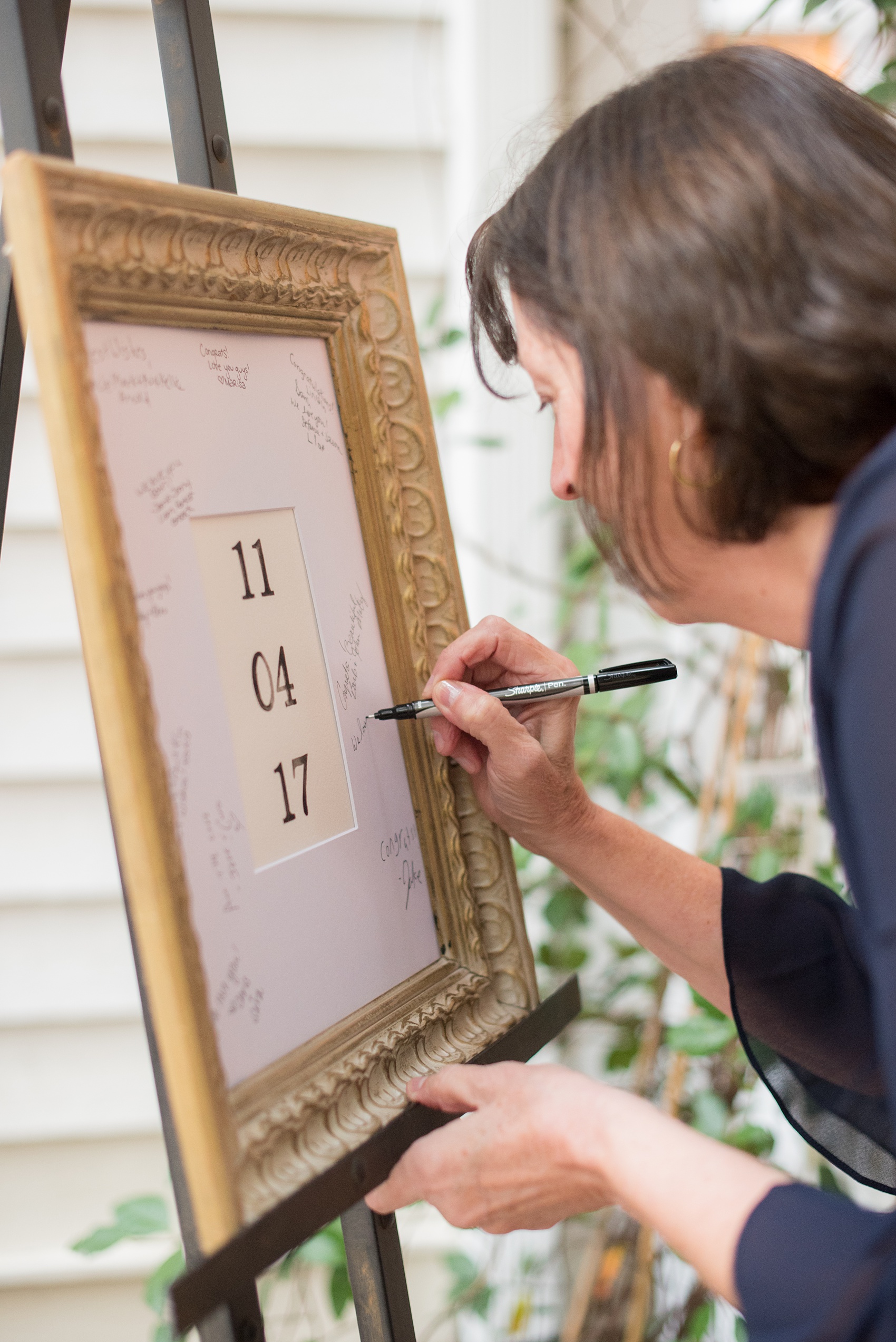 Mikkel Paige Photography photos from Leslie-Alford Mims House in North Carolina. Picture of a guest signing their wedding date frame board.