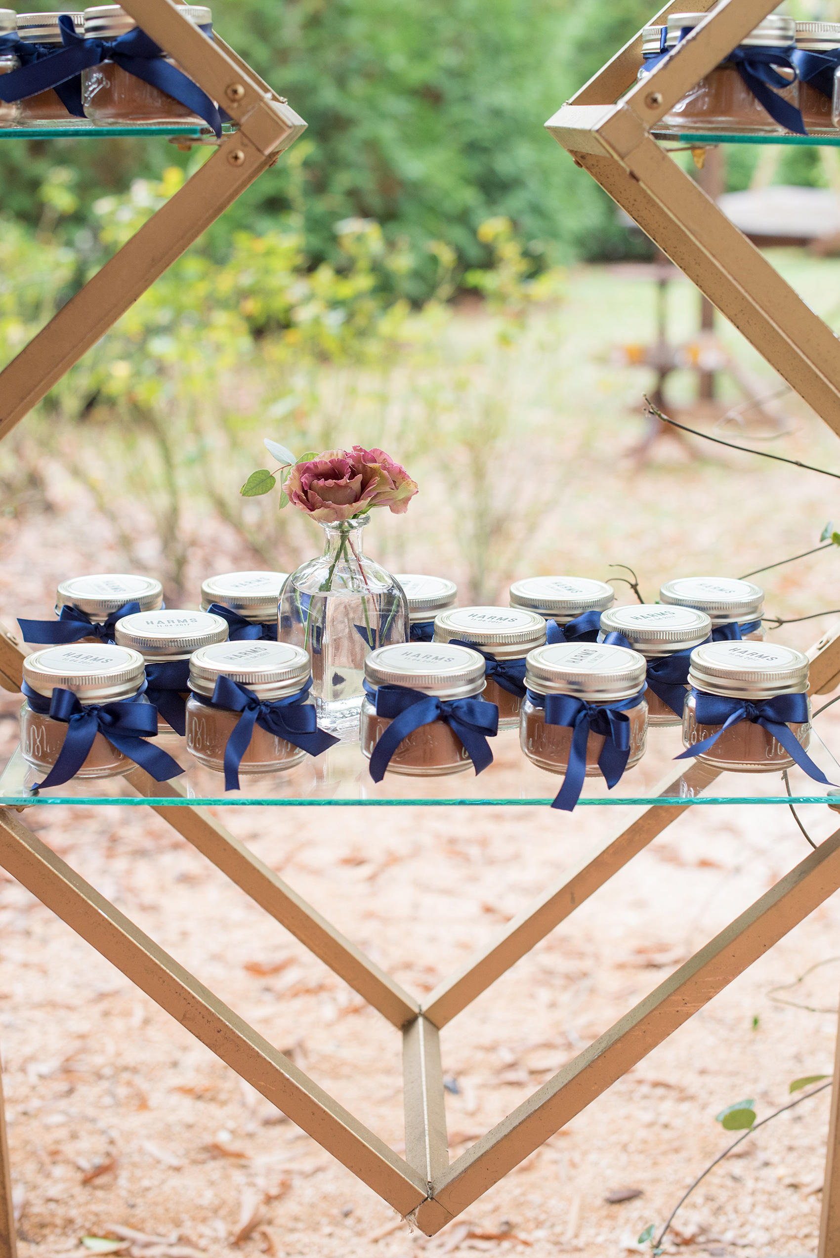 Mikkel Paige Photography photos from a wedding at Leslie-Alford Mims House in North Carolina. Picture of the gifts on a geometric metal display with blue ribbons and custom tags.