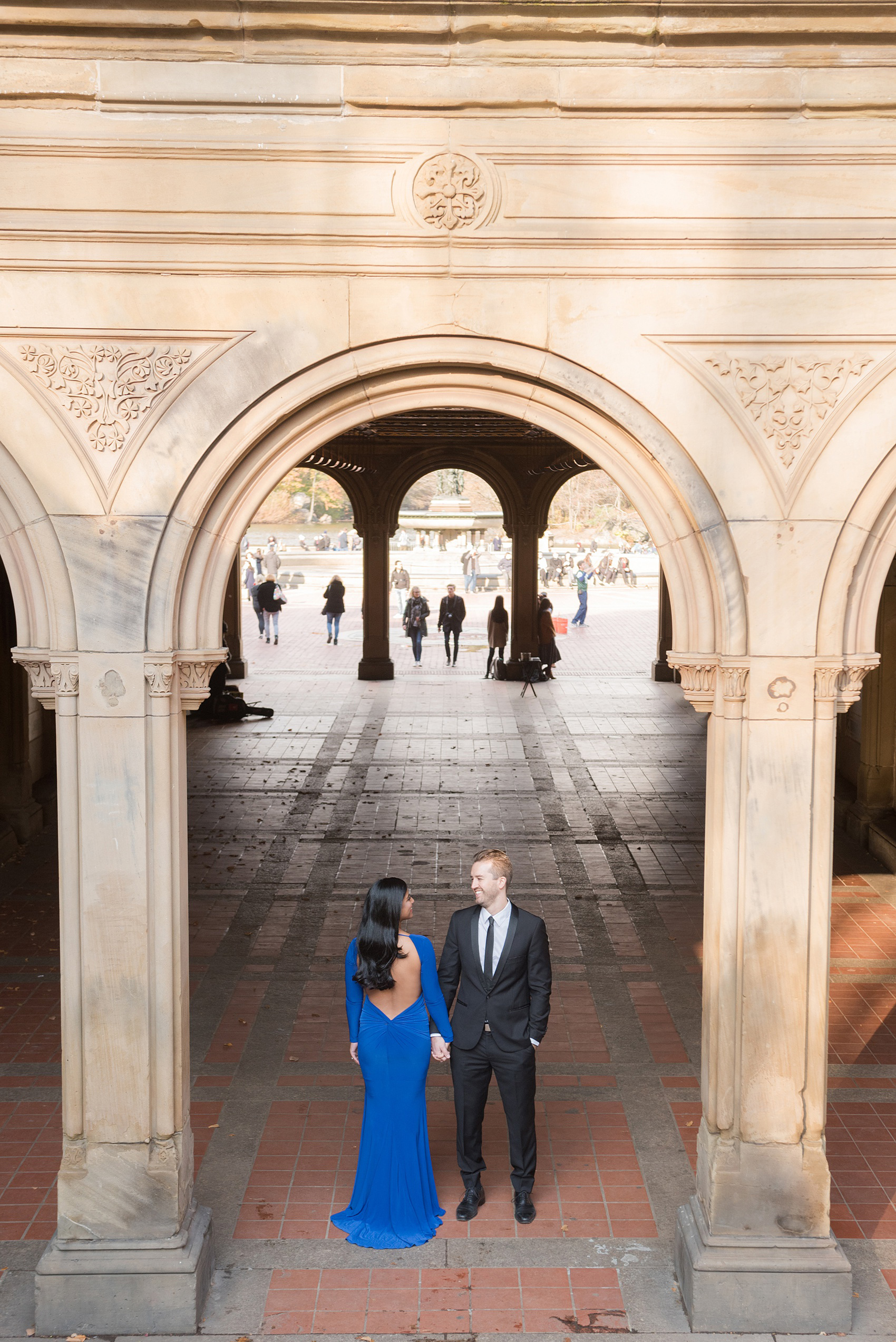 Mikkel Paige Photography pictures of an engagement session in Central Park. The bride wore a cobalt blue gown and groom in a suite.