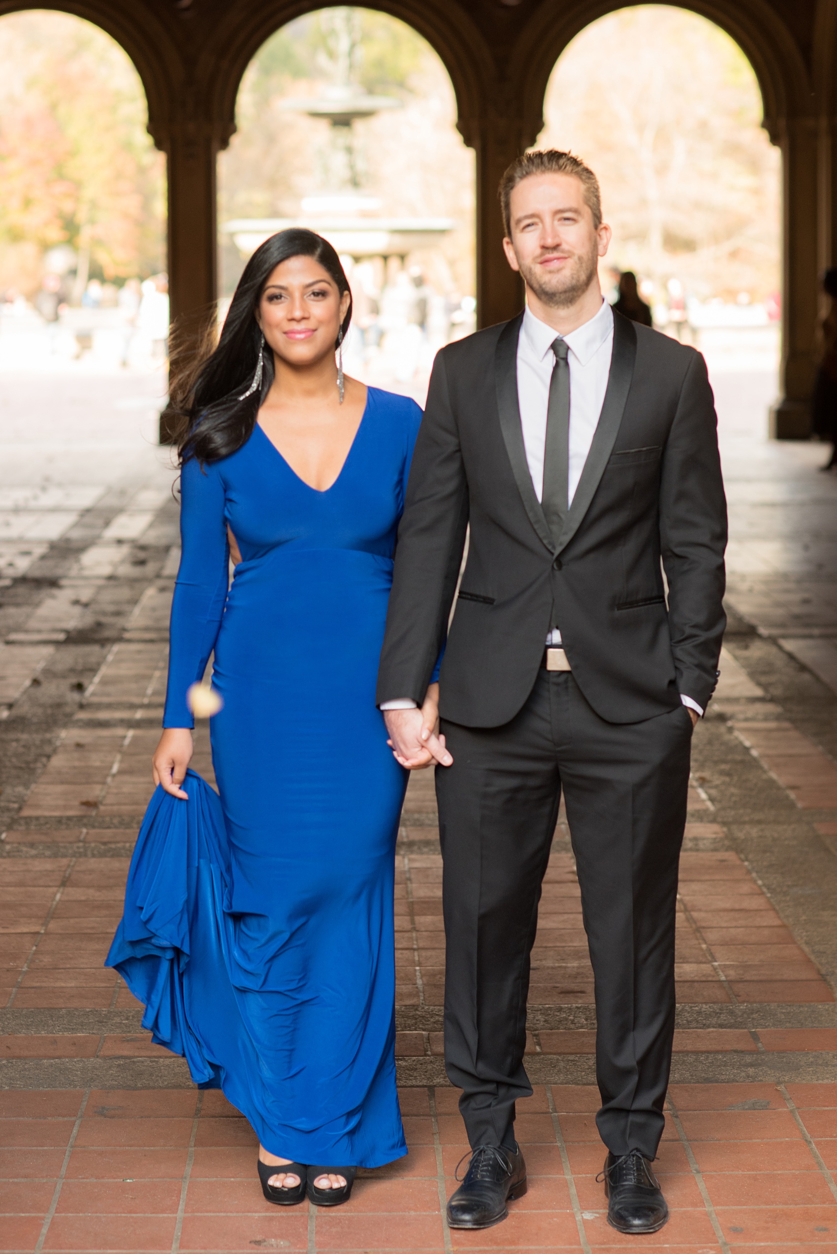 Mikkel Paige Photography pictures of an engagement session in Central Park. The bride wore a cobalt blue gown and groom in a suite.