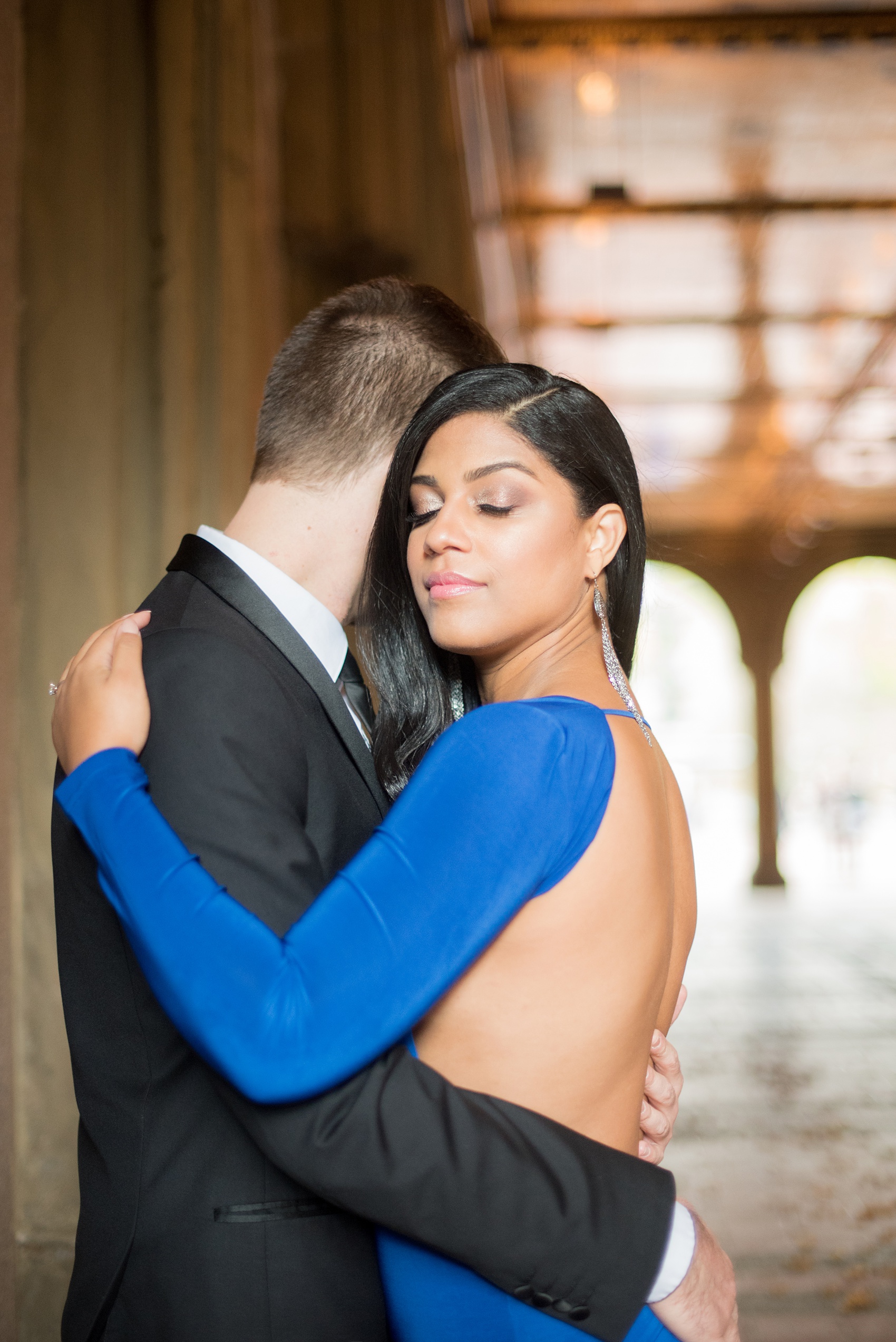 Mikkel Paige Photography pictures of an engagement session in Central Park. The bride wore a sexy back cobalt blue dress for a photo by Bethesda Terrace.