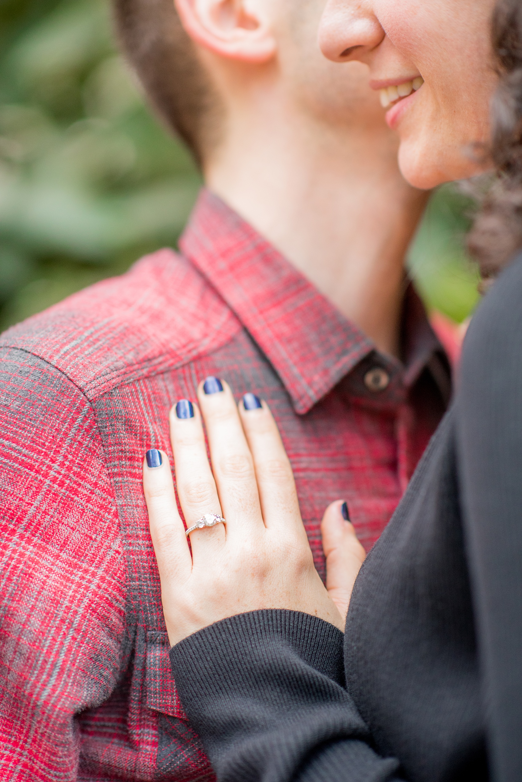 Mikkel Paige Photography engagement photos in lower manhattan near City Hall and the Brooklyn Bridge. Detail picture of the bride's hand with a three stone diamond ring.