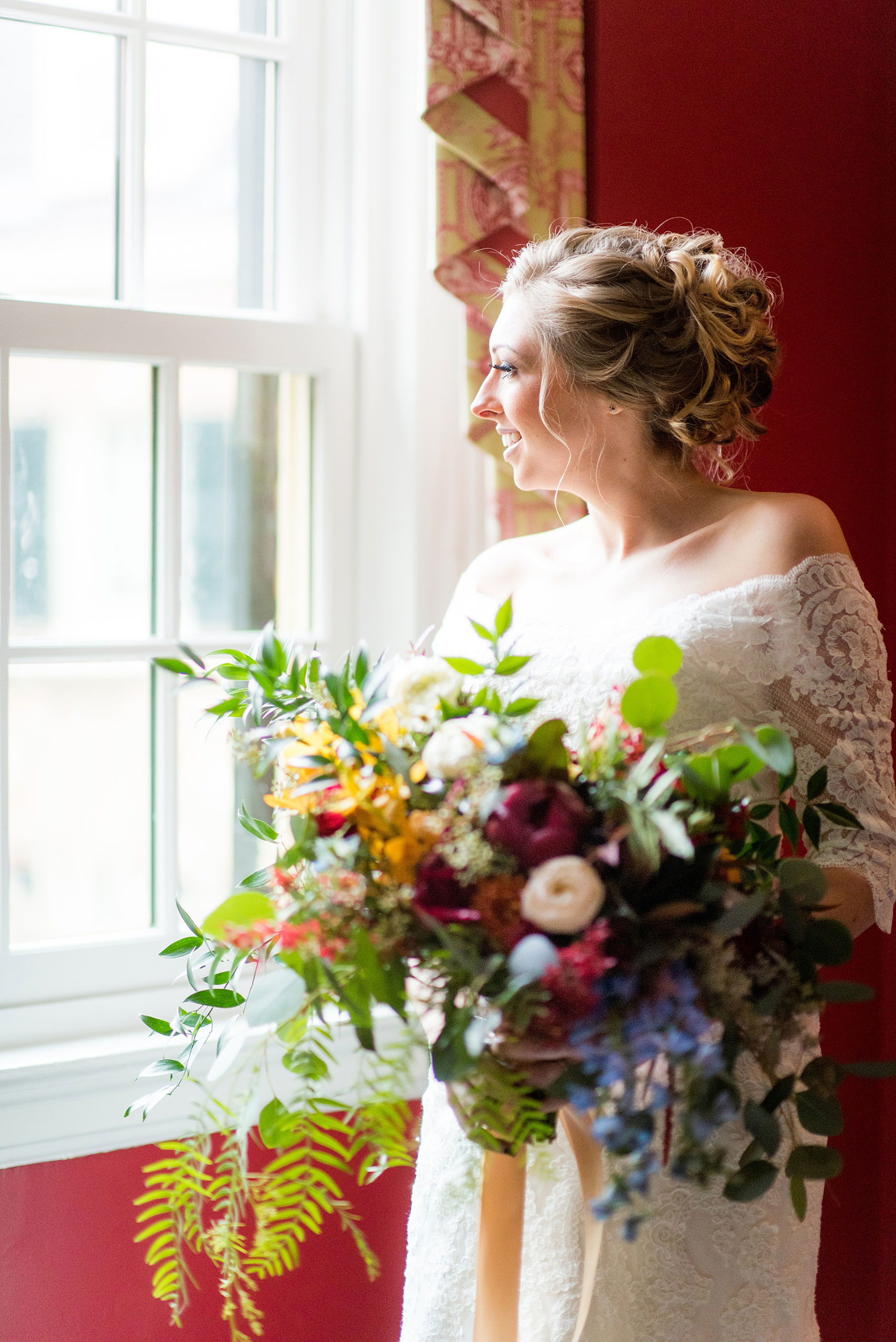 Mikkel Paige Photography photos at The Carolina Inn for a warm and colorful winter wedding. Picture of the bride looking out the window on a snowy day.