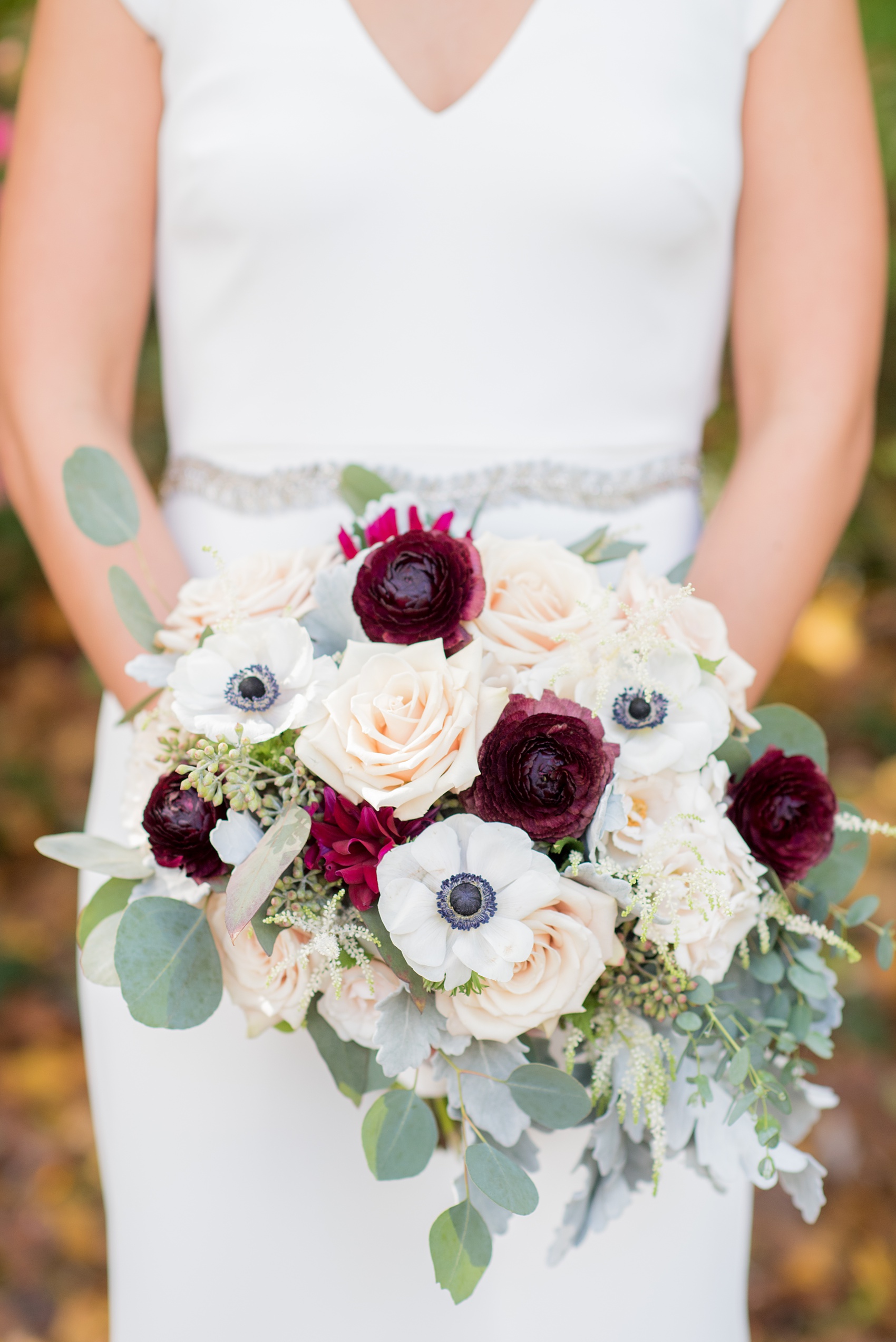 Mikkel Paige Photography photos of a wedding at Crabtree's Kittle House in Chappaqua, New York. Picture of the bride's fall inspired bouquet with dark red dahlias, white anemones and cream roses.