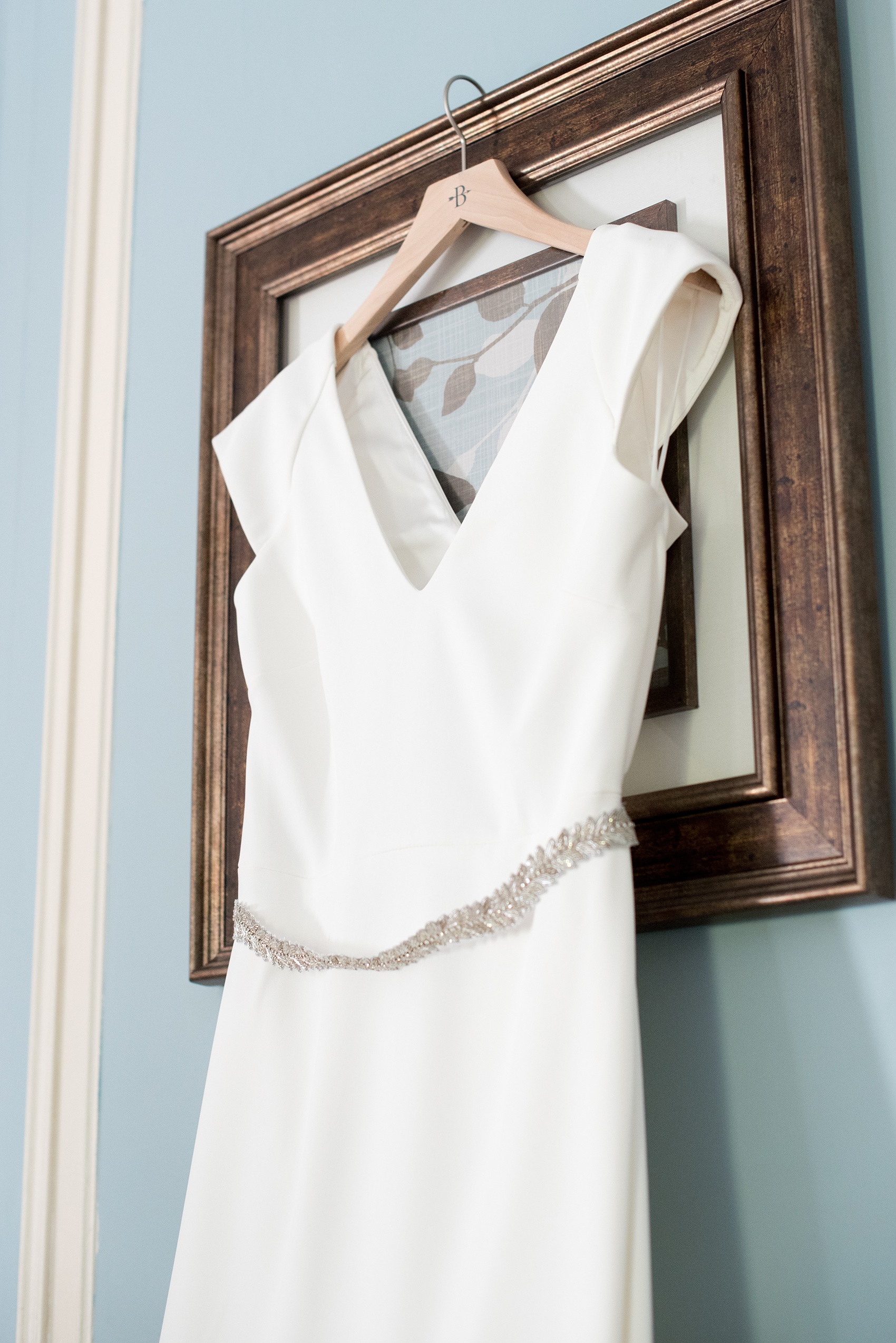 Mikkel Paige Photography photos of a wedding at Crabtree's Kittle House in Chappaqua, New York. Picture of the bride's simple BHLDN gown with a cutout in the back and rhinestone belt.