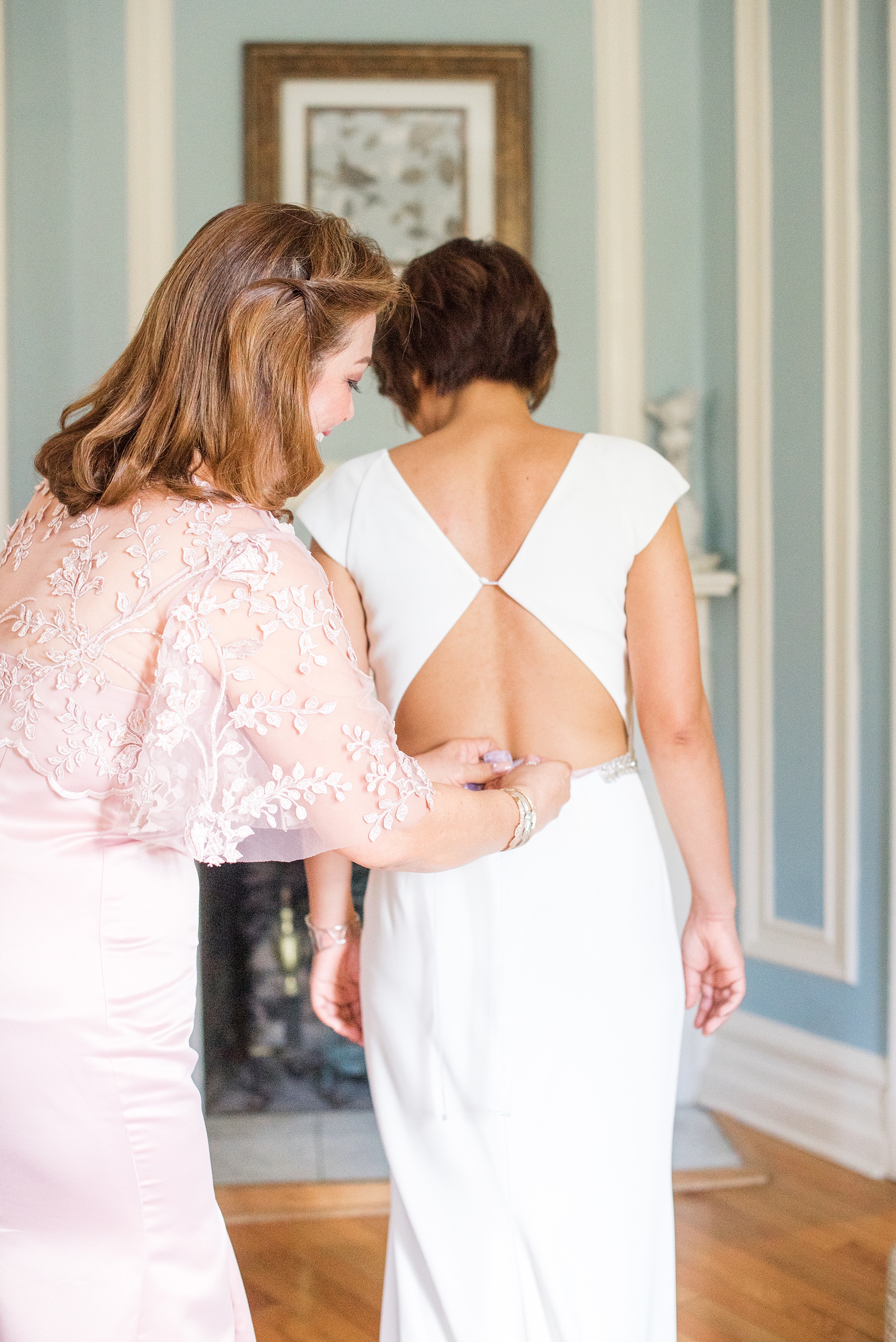 Mikkel Paige Photography photos of a wedding at Crabtree's Kittle House in Chappaqua, New York. Picture of the bride's mother helping her get ready.