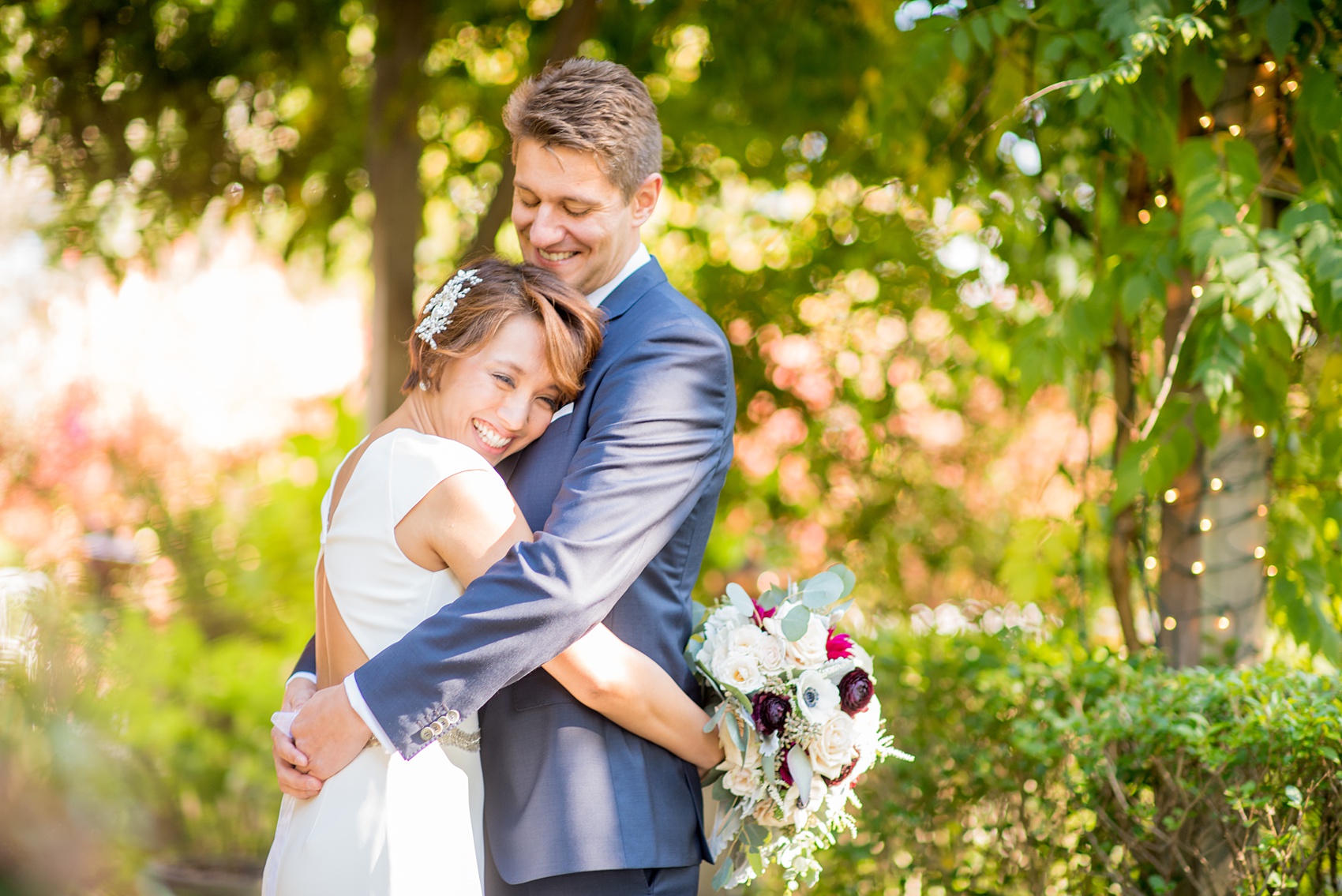 Mikkel Paige Photography photos of a wedding at Crabtree's Kittle House in Chappaqua, New York. Picture of the bride and groom hugging amidst the garden.