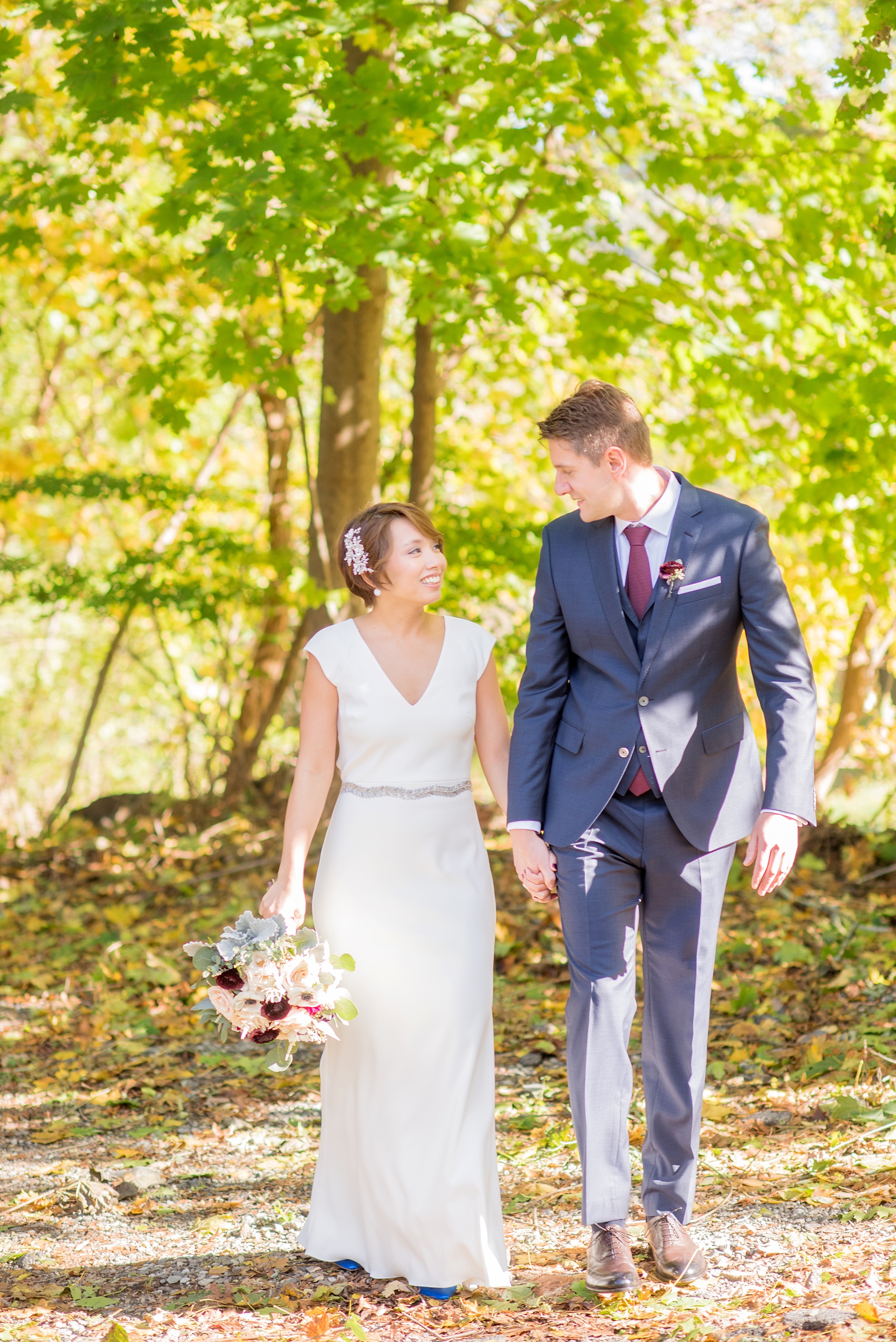 Mikkel Paige Photography photos of a wedding at Crabtree's Kittle House in Chappaqua, New York. Picture of the bride and groom walking amidst green trees.