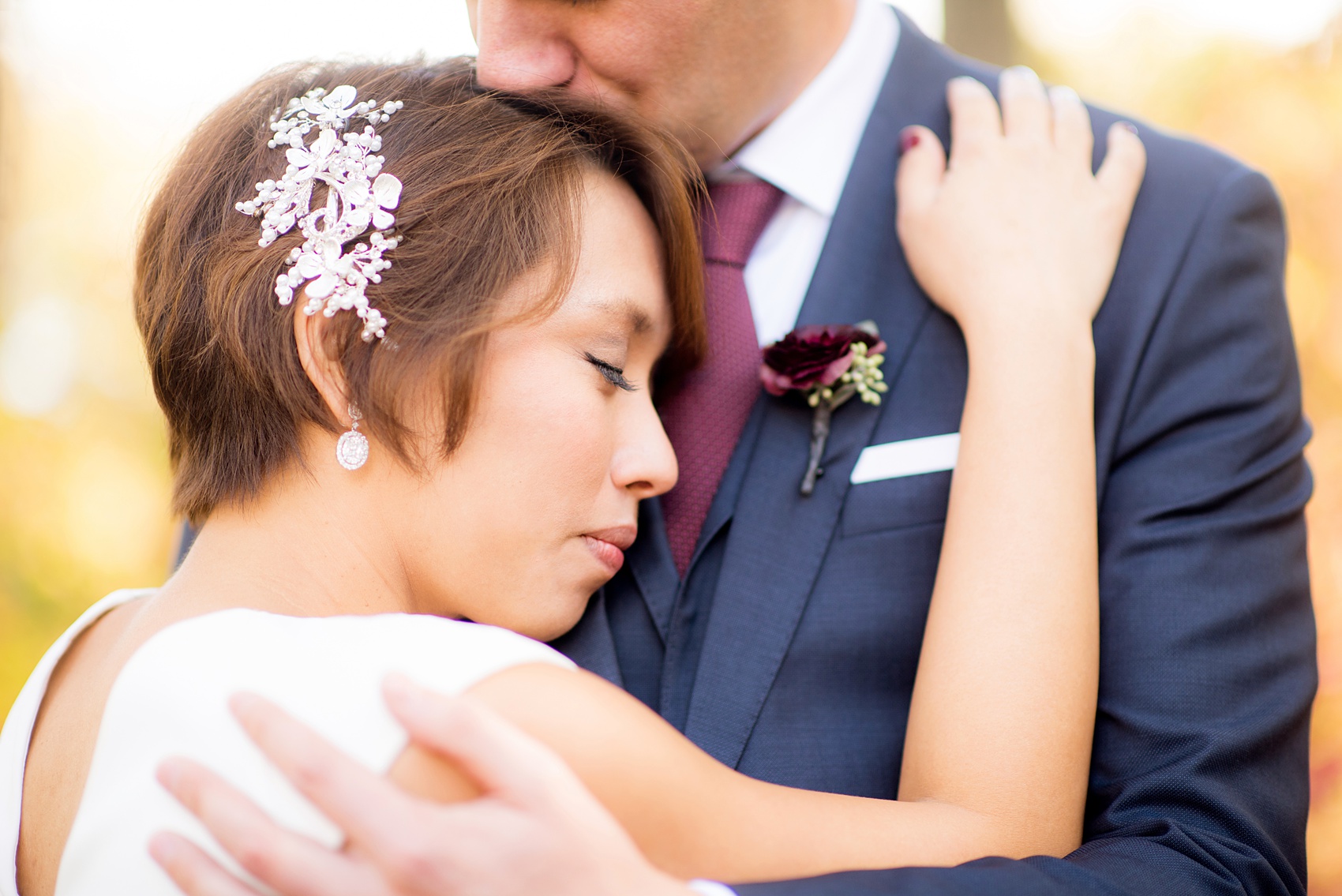 Mikkel Paige Photography photos of a wedding at Crabtree's Kittle House in Chappaqua, New York. Picture of the bride hugging her groom on their fall day.