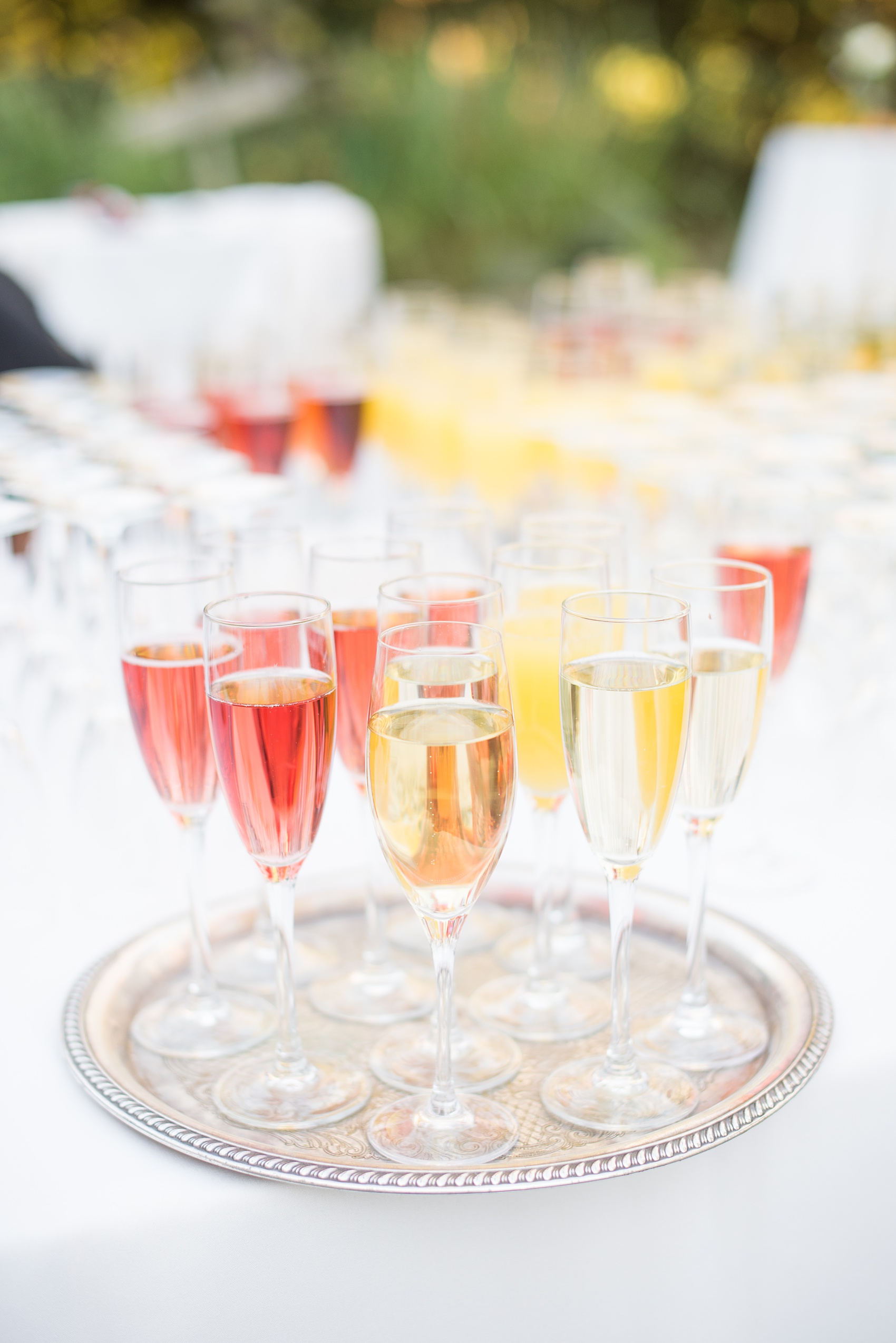 Mikkel Paige Photography photos of a wedding at Crabtree's Kittle House in Chappaqua, New York. Picture of champagne flutes filled with various bubbles during cocktail hour.