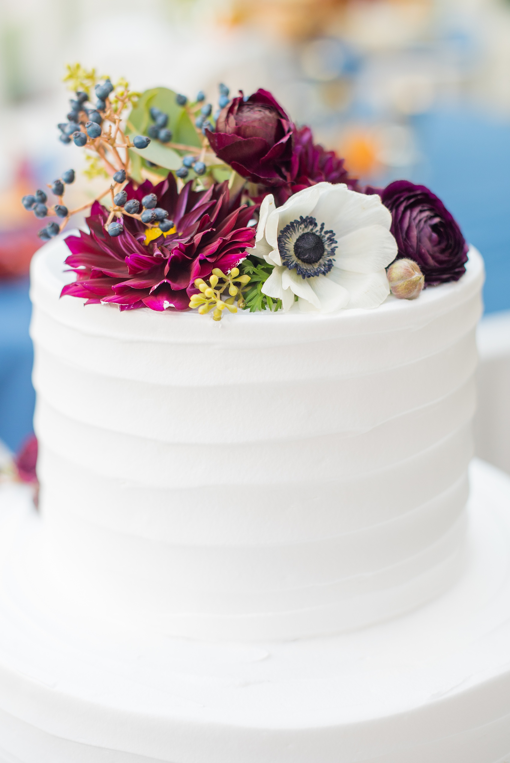 Mikkel Paige Photography photos of a wedding at Crabtree's Kittle House in Chappaqua, New York. Picture of the white buttercream cake decorated with fresh fall flowers.