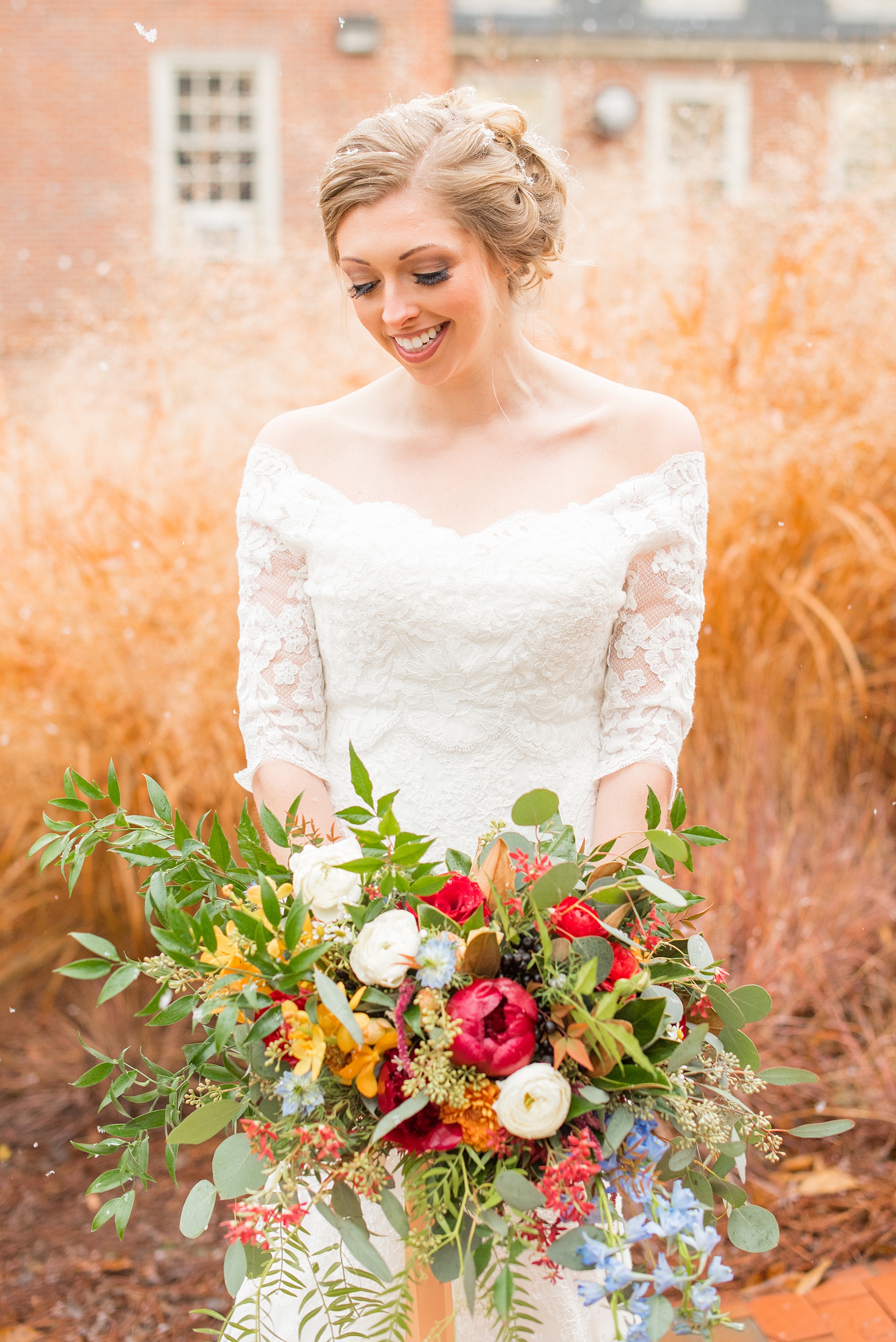 Beautiful wedding photos at The Carolina Inn at Chapel Hill, North Carolina by Mikkel Paige Photography. Detail photo of the bride's bouquet with fall and winter flowers, with burgundy peonies, cascading fern, white ranunculus and orange orchids created by English Garden. Click through to see the rest of this gorgeous winter wedding! #thecarolinainn #snowywedding