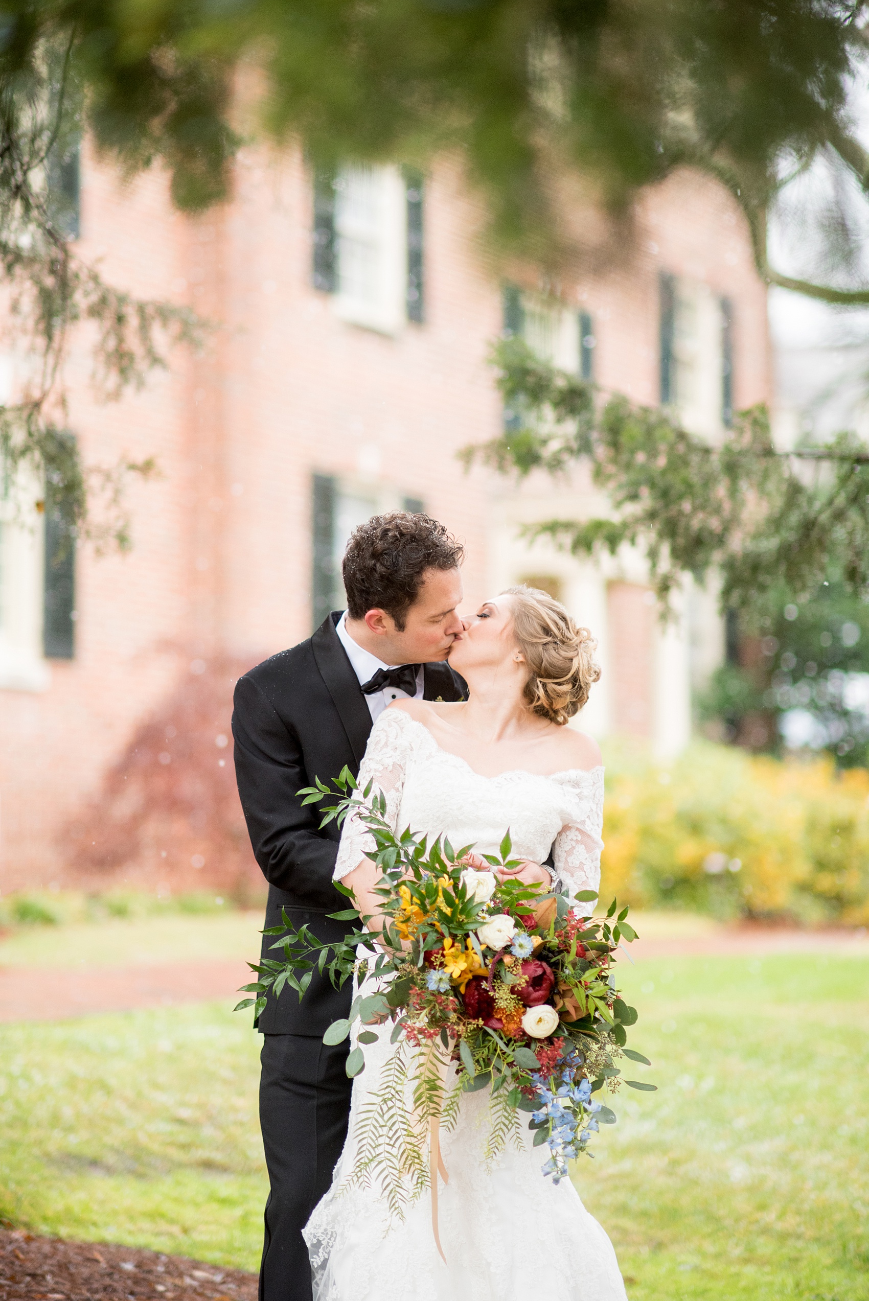 Beautiful wedding photos at The Carolina Inn at Chapel Hill, North Carolina by Mikkel Paige Photography. Photo of the bride and groom's winter wedding, kissing by an evergreen tree at this southern venue. Click through to see the rest of this gorgeous winter wedding! #thecarolinainn #snowywedding