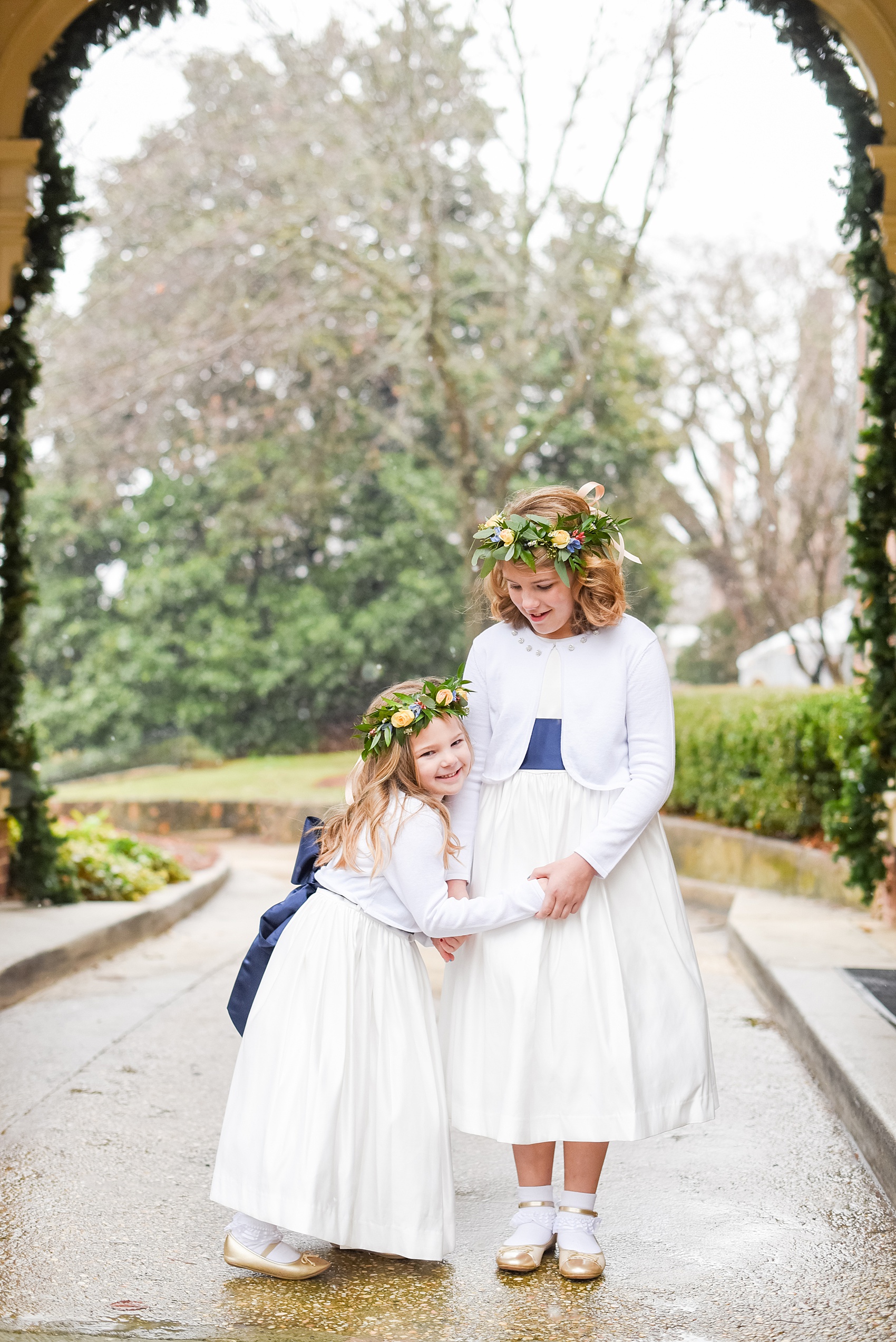 Beautiful wedding photos at The Carolina Inn at Chapel Hill, North Carolina by Mikkel Paige Photography. Photo of the flower girls with navy blue sashes and flower crowns. Click through to see the rest of this gorgeous winter wedding! #thecarolinainn #snowywedding