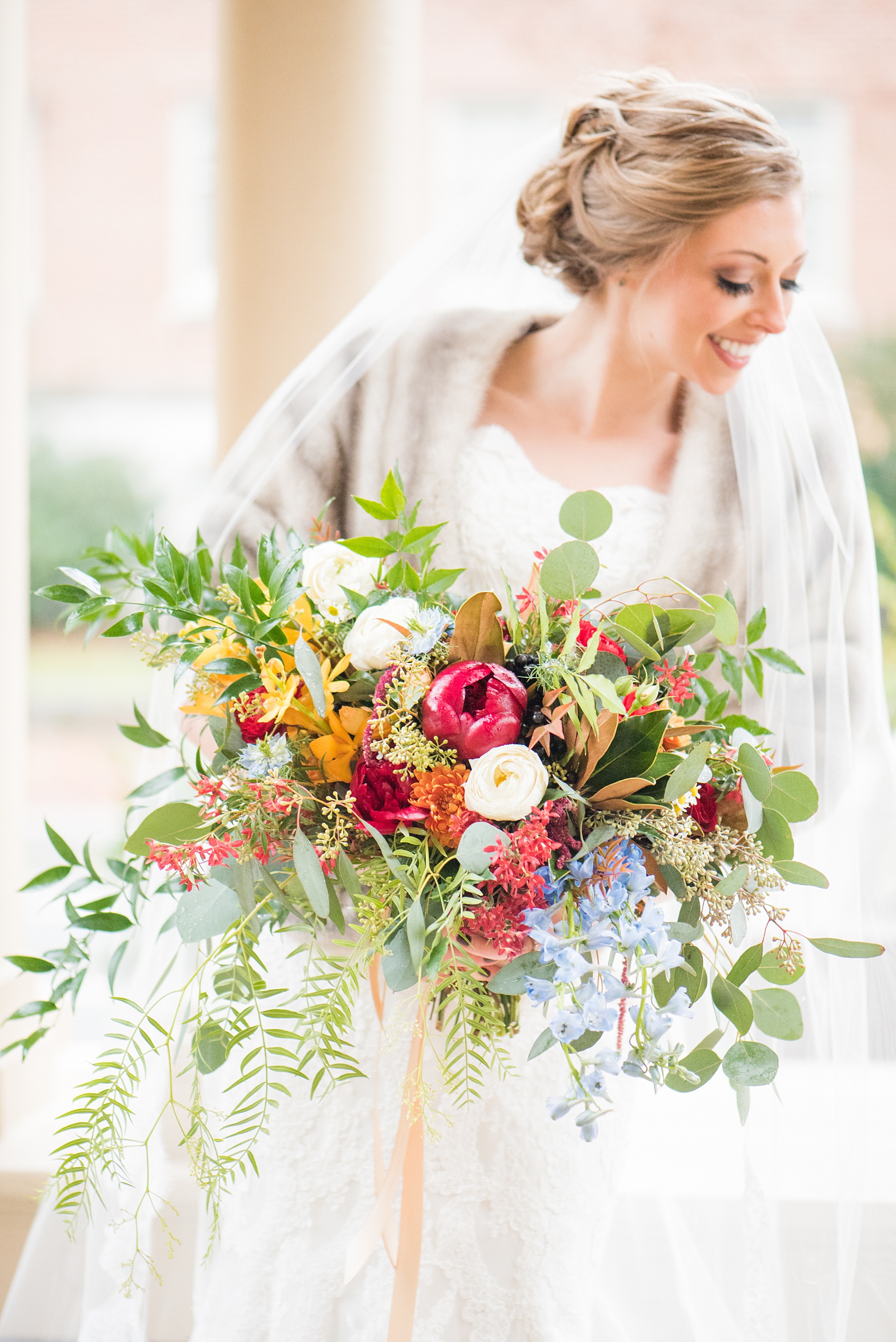 Beautiful wedding photos at The Carolina Inn at Chapel Hill, North Carolina by Mikkel Paige Photography. Detail photo of the bride's bouquet with fall and winter flowers, with burgundy peonies, cascading fern, white ranunculus and orange orchids created by English Garden. Click through to see the rest of this gorgeous winter wedding! #thecarolinainn #snowywedding