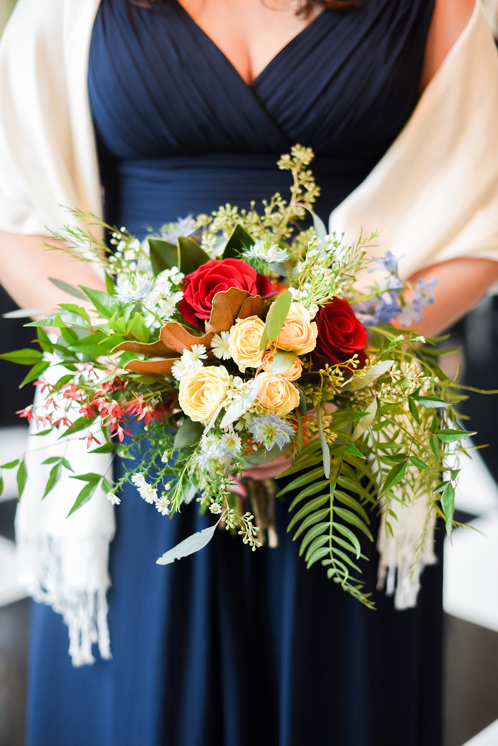 Beautiful wedding photos at The Carolina Inn at Chapel Hill, North Carolina by Mikkel Paige Photography. Picture of the bridesmaids bouquets, complete with green ferns, red roses, kangaroo paw, yellow spray roses and blue accents by English Garden. Click through to see the rest of this gorgeous winter wedding! #thecarolinainn #snowywedding
