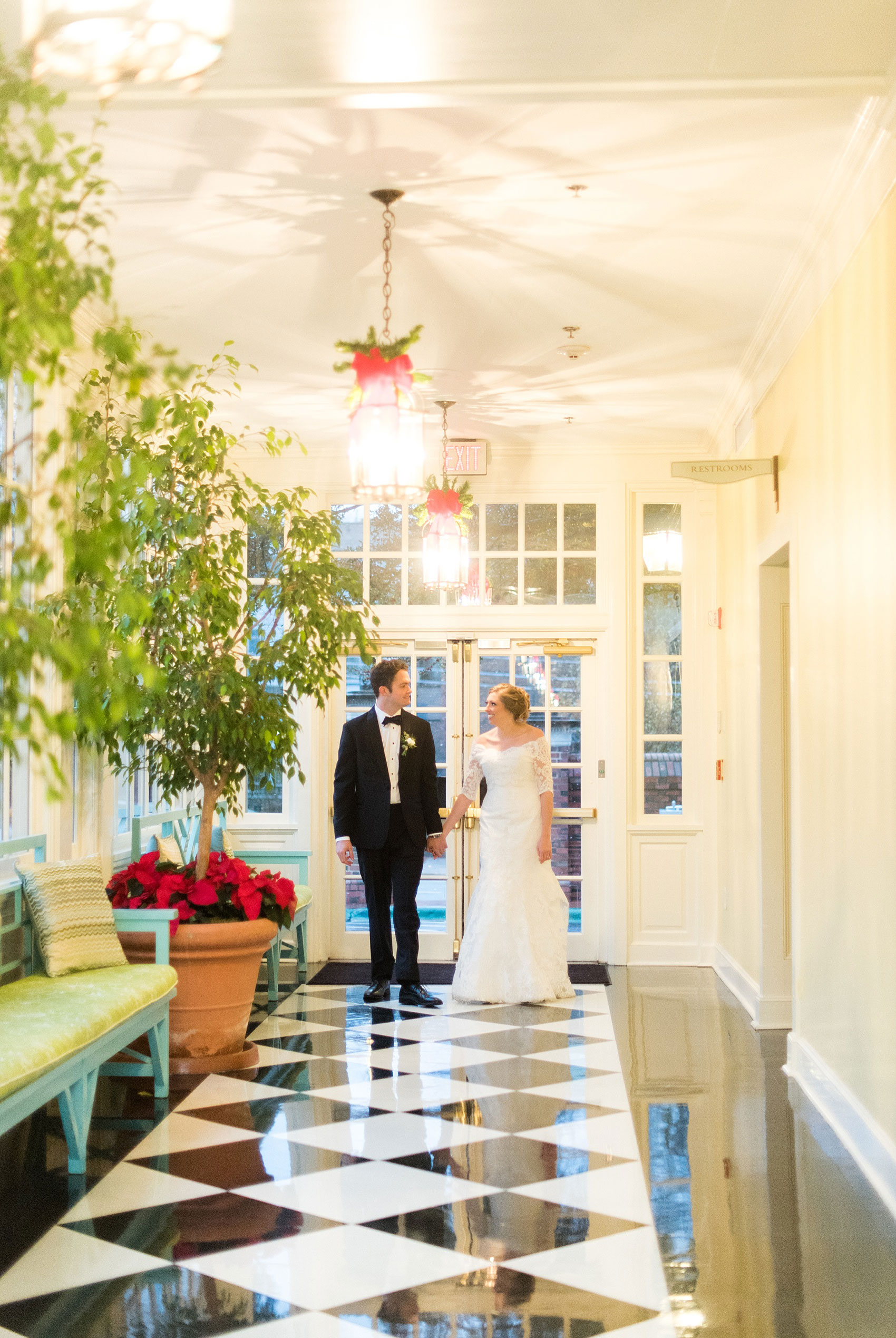 Beautiful wedding photos at The Carolina Inn at Chapel Hill, North Carolina by Mikkel Paige Photography. Picture of the bride and groom walking through the hallway with a black and white checkerboard floor. Click through to see the rest of this gorgeous winter wedding! #thecarolinainn #snowywedding
