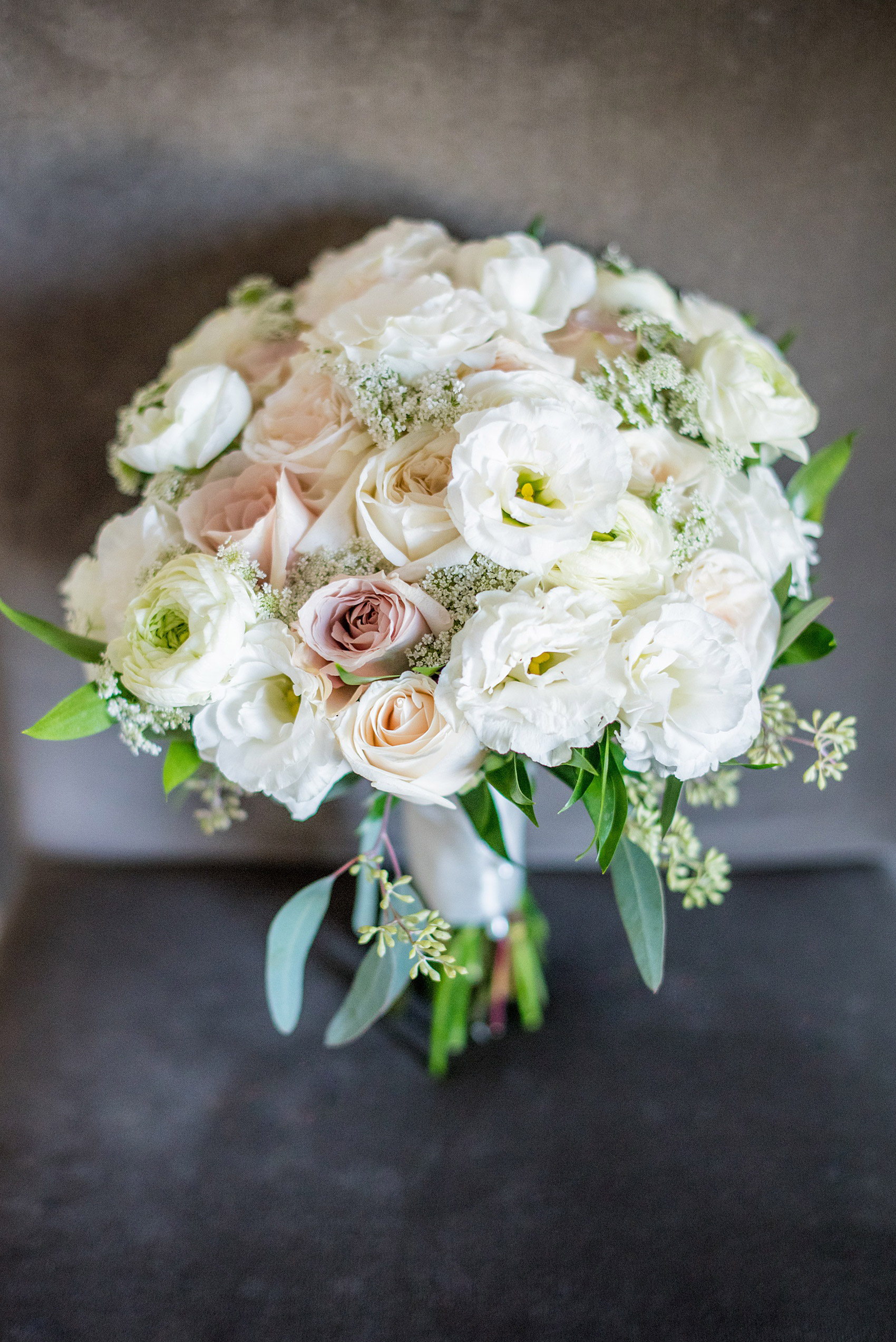 Photos by Mikkel Paige Photography of a Central Park Wedding ceremony and reception at the Loeb Boathouse venue with a romantic theme. Detail picture of the bride's ranunculus, rose and Queen Anne's Lace bouquet for her winter wedding. Click through for more images from her day! #CentralParkWedding