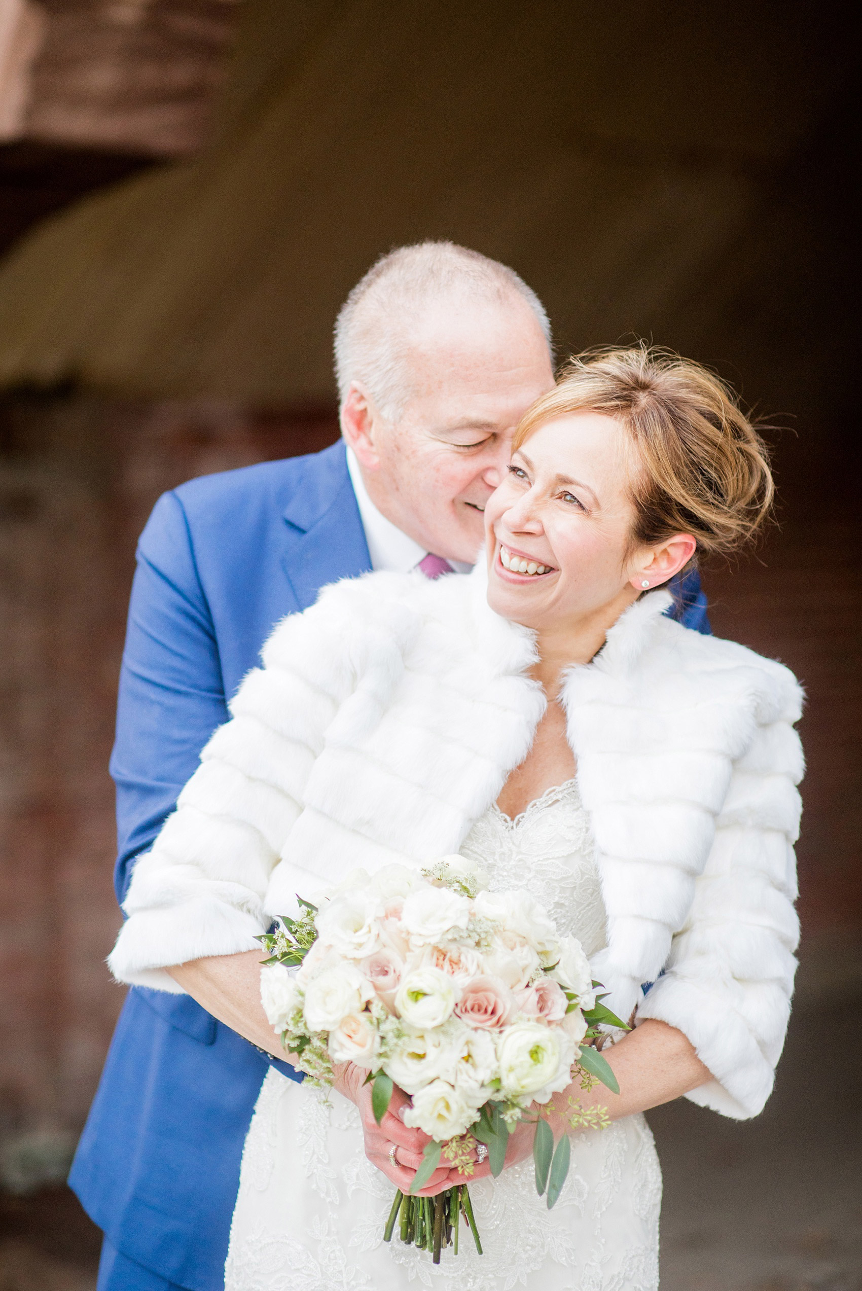 Photos by Mikkel Paige Photography of a Central Park Wedding ceremony and reception at the Loeb Boathouse venue with a romantic winter theme. The bride and groom took pictures around the park in his custom navy blue suit and her lace gown with short white fur coat. Click through for more images from their day! #CentralParkWedding