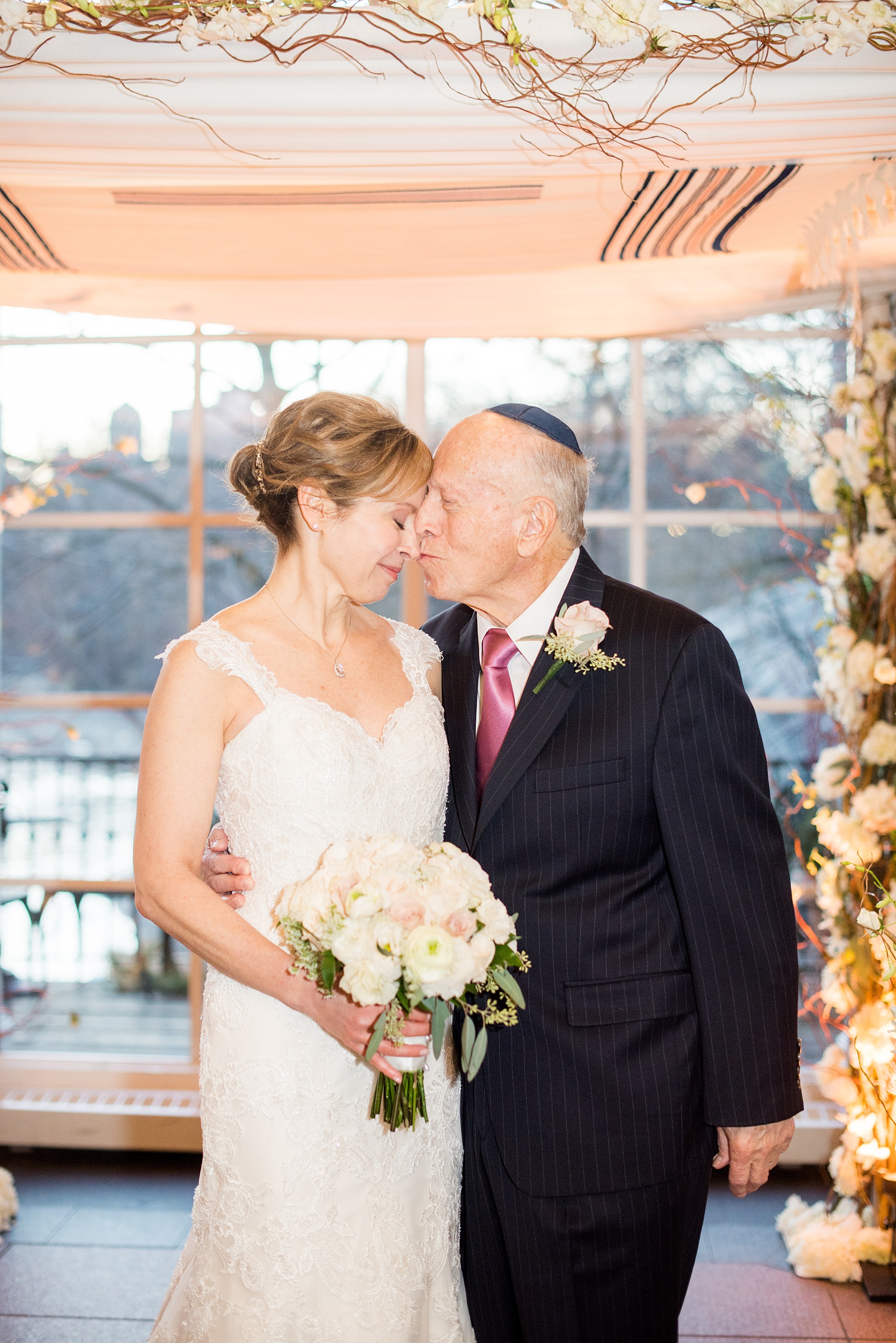 Photos by Mikkel Paige Photography of a Central Park Wedding reception at the Loeb Boathouse venue with a romantic theme. Picture of the father of the bride with his daughter under the winter inspired chuppah for their Jewish ceremony. Click through for more images from her day! #CentralParkWedding