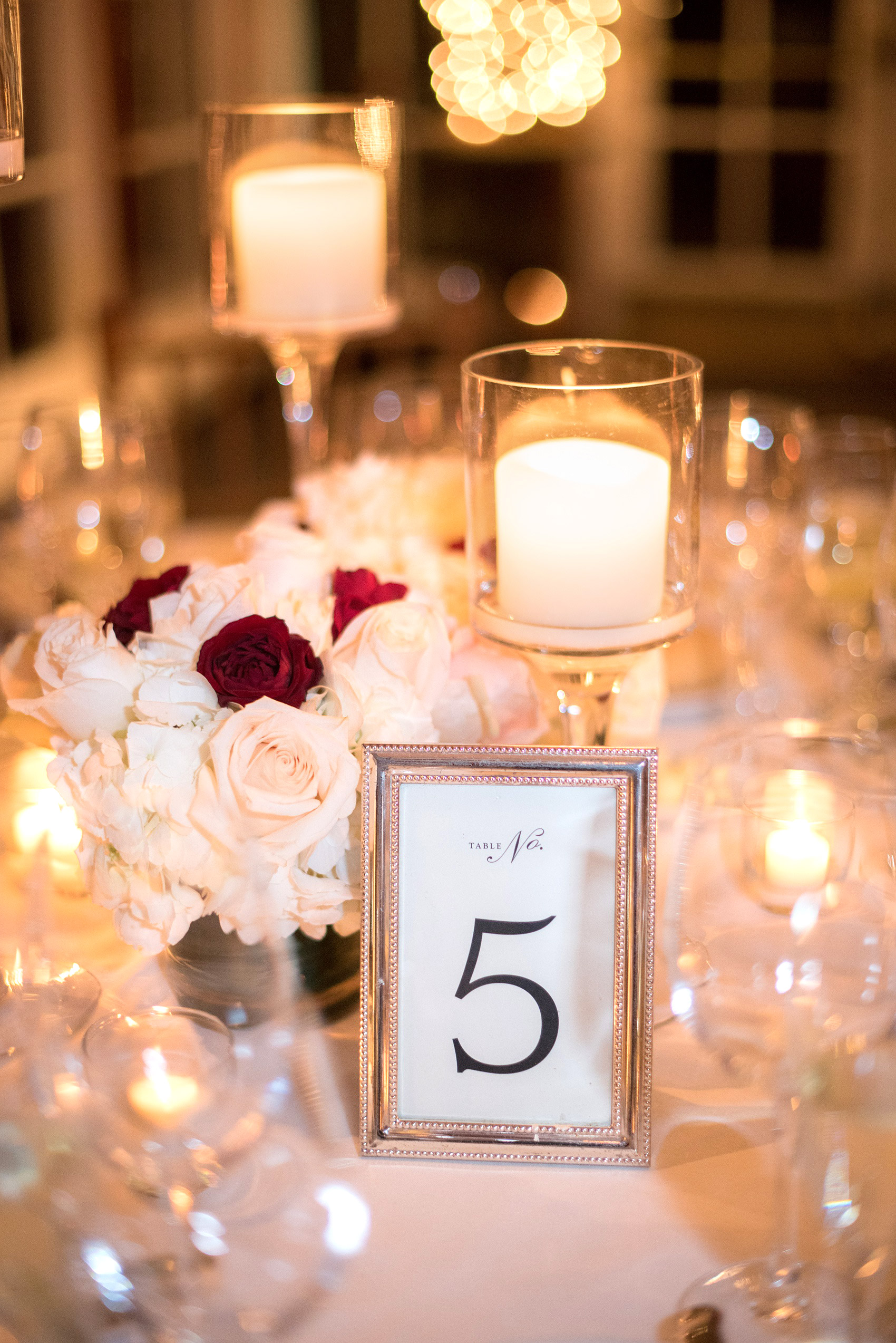 Photos by Mikkel Paige Photography of a Central Park Wedding ceremony and reception at the Loeb Boathouse venue with a romantic theme. Picture of the winter white inspired party with candlelight. Short centerpieces included roses and hydrangea. Click through for more images from the day! #CentralParkWedding