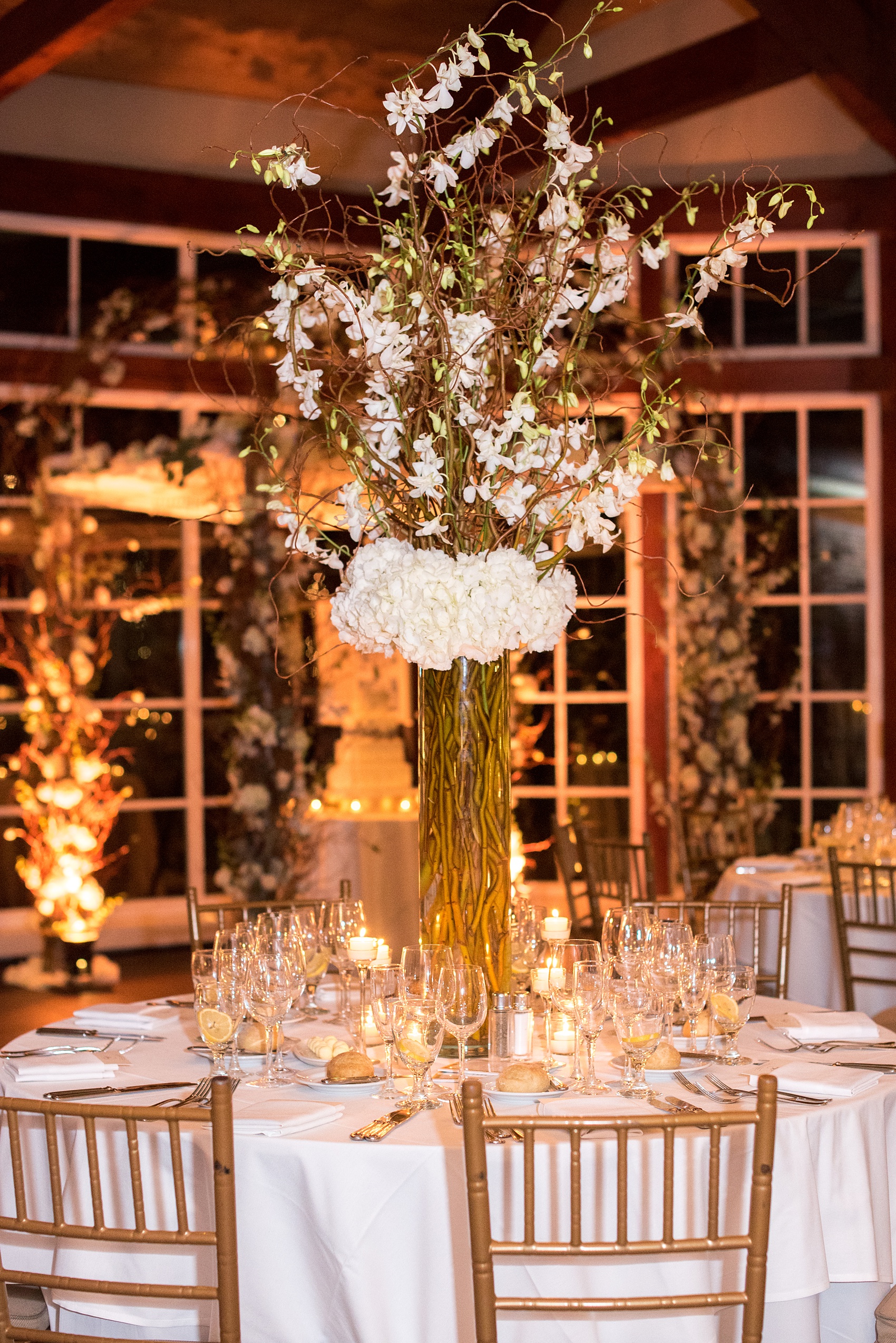 Photos by Mikkel Paige Photography of a Central Park Wedding ceremony and reception at the Loeb Boathouse venue with a romantic theme. Picture of the winter white inspired party with candlelight. Tall centerpieces included orchids and hydrangea. Click through for more images from the day! #CentralParkWedding