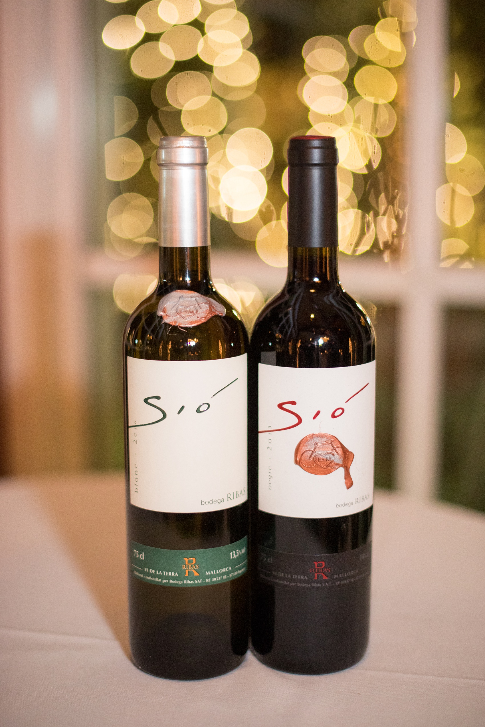 Photos by Mikkel Paige Photography of a Central Park Wedding reception at the Loeb Boathouse venue with a romantic winter theme. Picture of the Spanish wine the groom specially got as a nod to where the couple got engaged. Click through for more images from this beautiful day! #CentralParkWedding