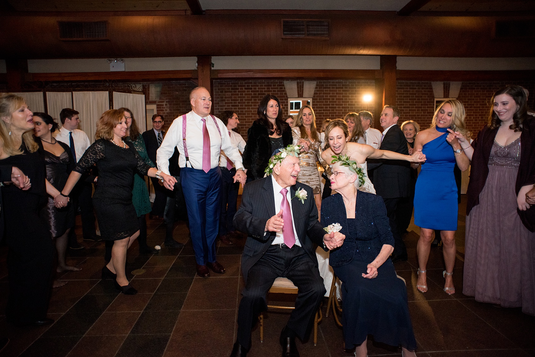 Photos by Mikkel Paige Photography of a Central Park Wedding reception at the Loeb Boathouse venue with a romantic winter theme. Picture of the Jewish tradition mizinke flower crowns and dance. Click through for more images from this beautiful day! #CentralParkWedding