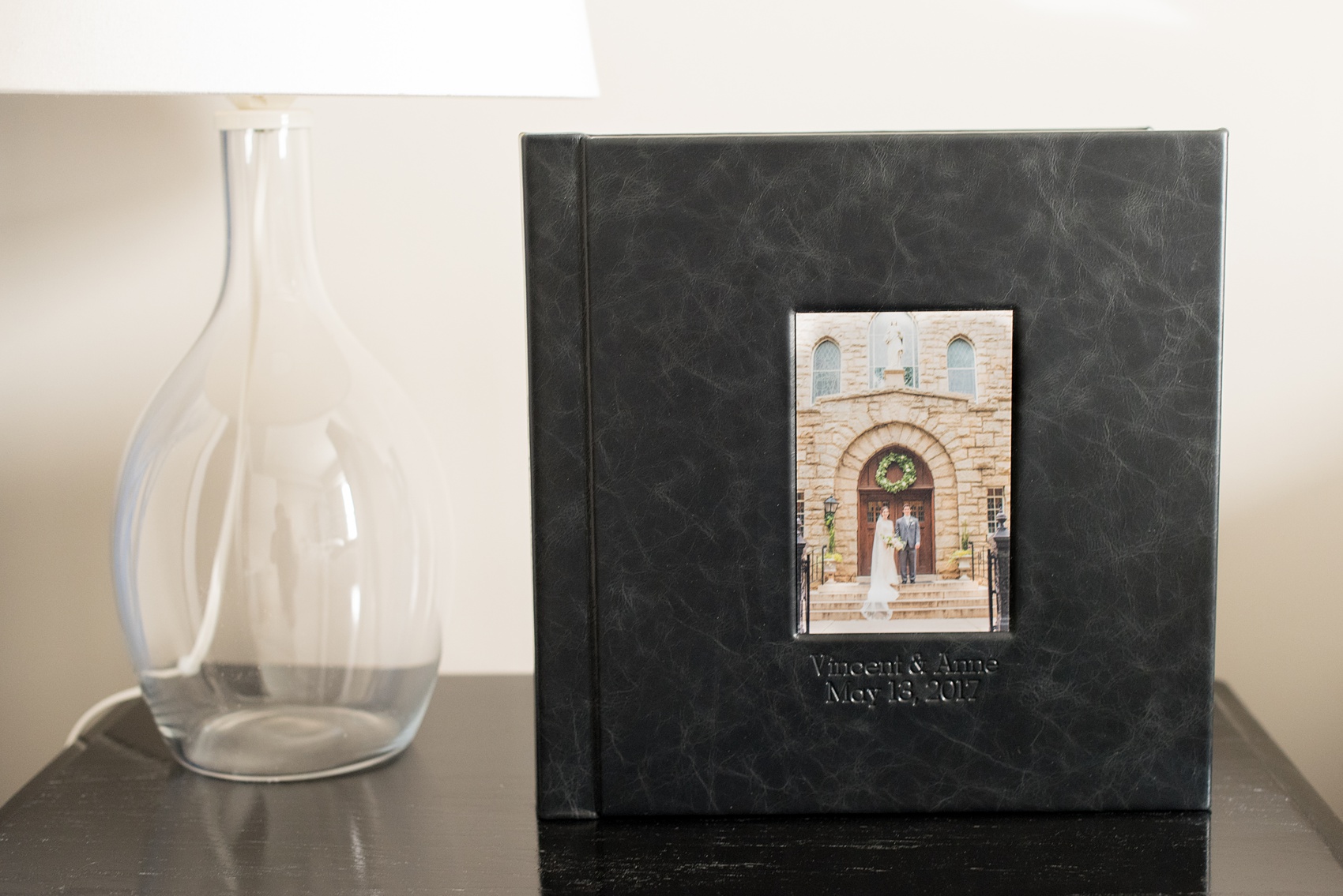 Images of a black calf leather fine art wedding album from Mikkel Paige Photography, a Raleigh, NC photographer. Photo shows inset cover image and debossing text.