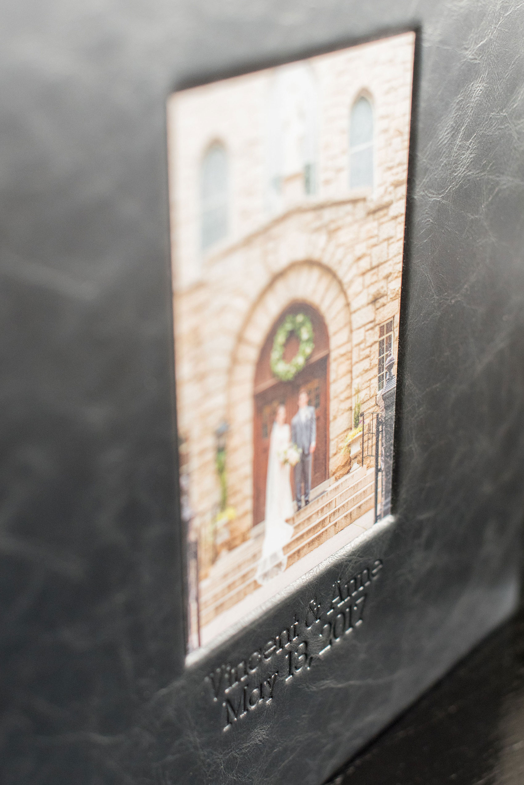 Images of a black calf leather fine art wedding album from Mikkel Paige Photography, a Raleigh, NC photographer. Photo shows inset cover image and debossing text.