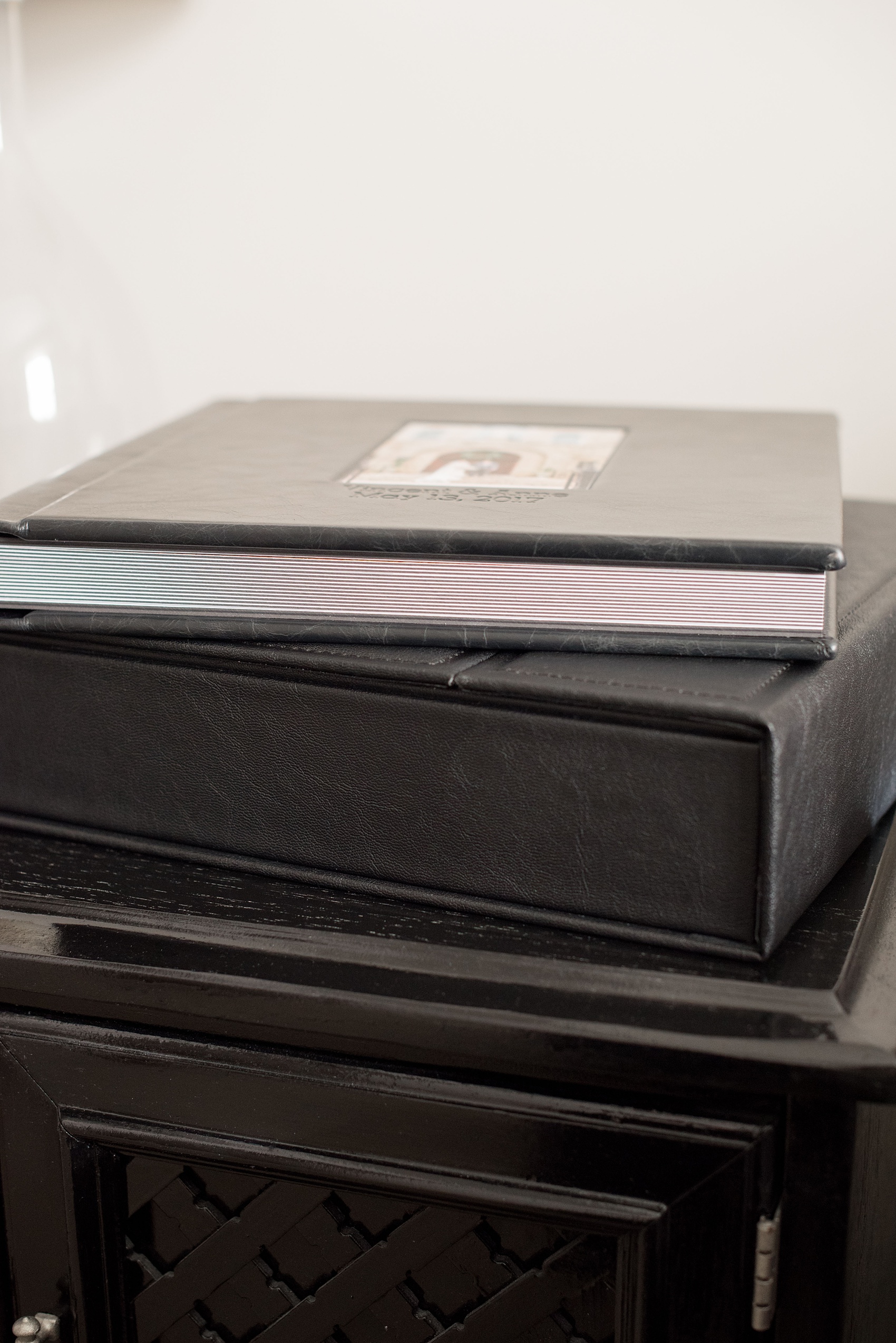 Images of a black calf leather fine art wedding album from Mikkel Paige Photography, a Raleigh, NC photographer. Photo shows side view of the spreads and page thickness.