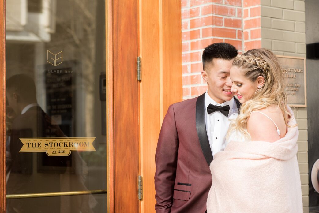 Photos from a wedding in downtown Raleigh, NC by Mikkel Paige Photography. The Stockroom at 230 and The Glass Box on historic Fayetteville Street served as the venue for this romantic inspiration shoot. The bride and groom cuddled under a pink blanket before entering their day.