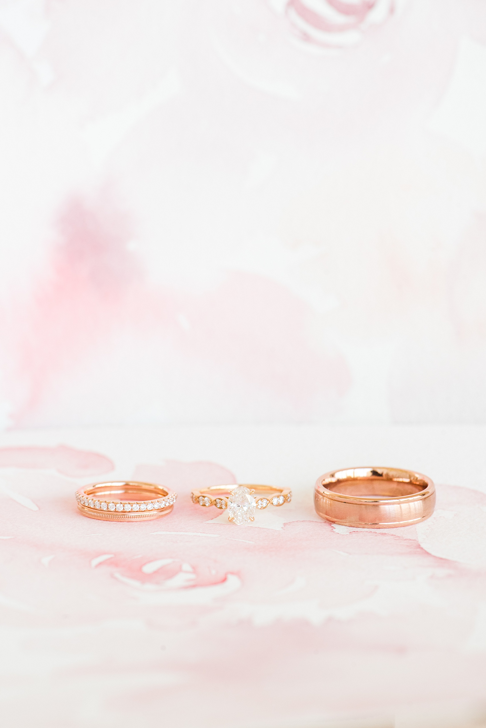 Photos from a wedding in downtown Raleigh, NC by Mikkel Paige Photography. The rose gold diamond rings are pictured in this detail image on watercolor designs by One and Only Paper. The bride had an oval center stone.