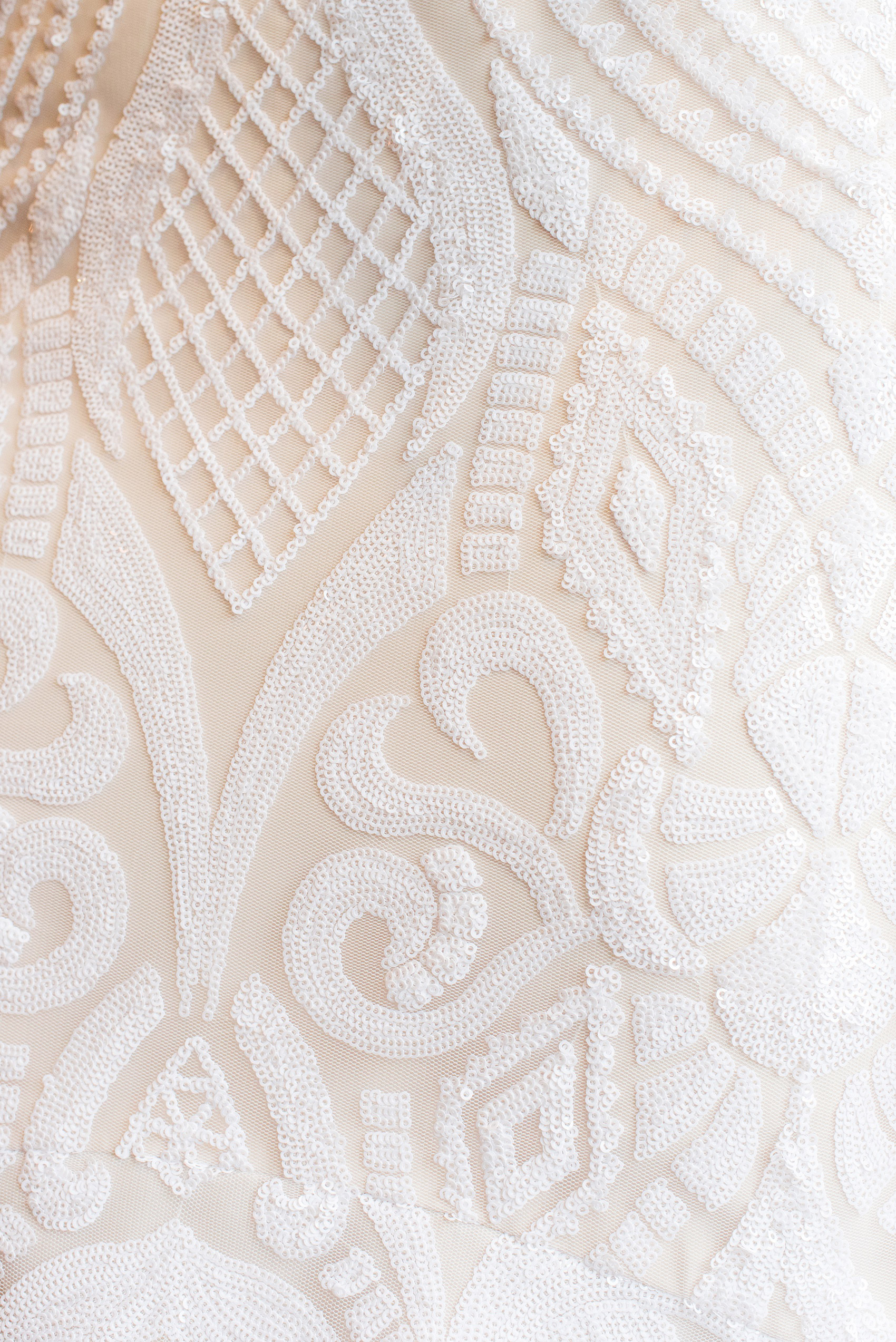 Photos from a wedding in downtown Raleigh, NC by Mikkel Paige Photography. A detail picture is shown of the pattern of the sequins on the Hayley Paige gown the bride wore from Tre Bella.